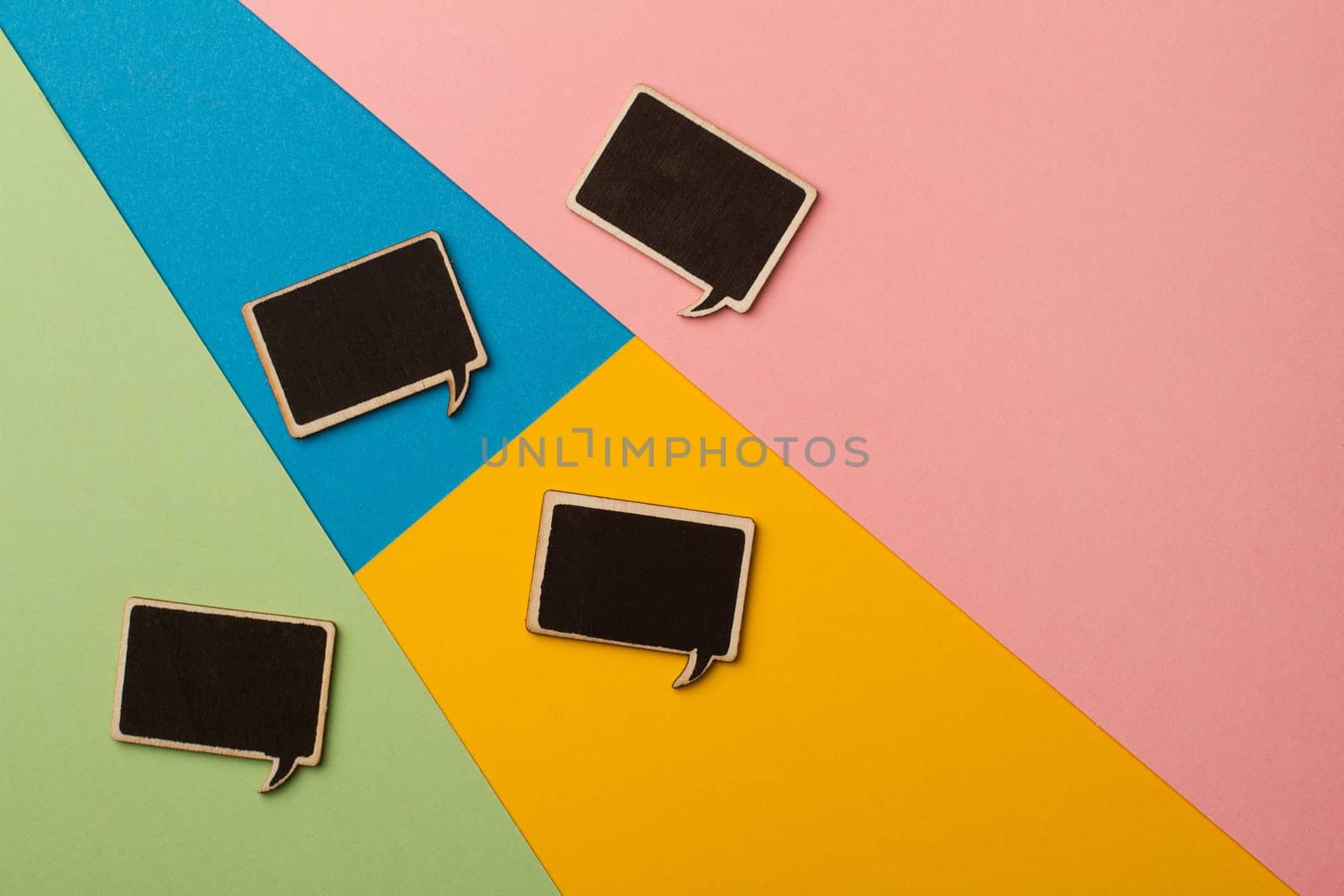 Top view of square chalk board speech bubbles on colored papers, metaphor, concept for communication
