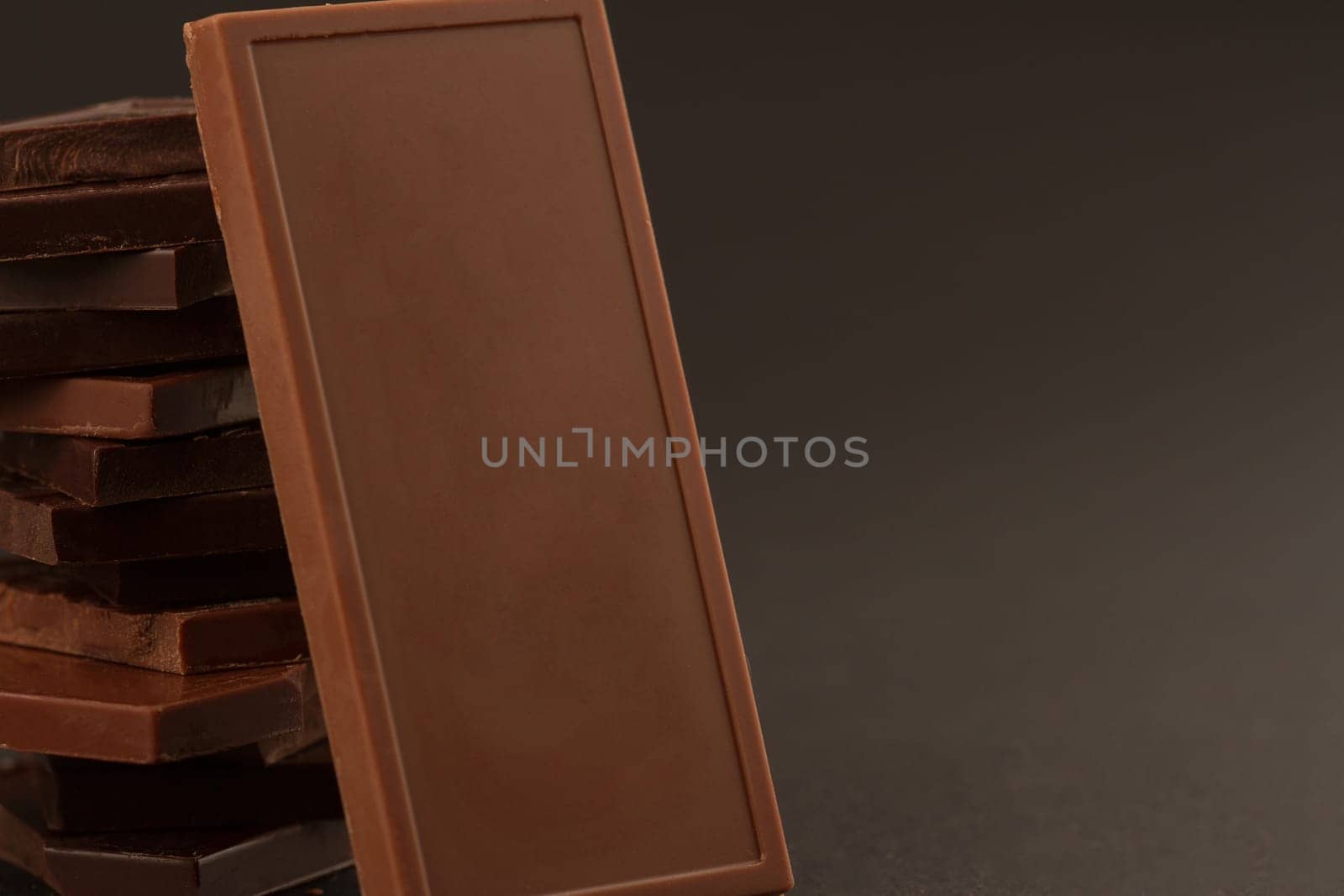 Front view of square shaped chocolate pieces isolated on dark background
