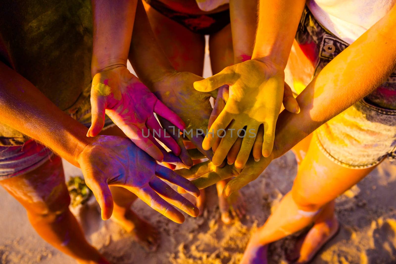 Teenagers playing with colored powder on the beach