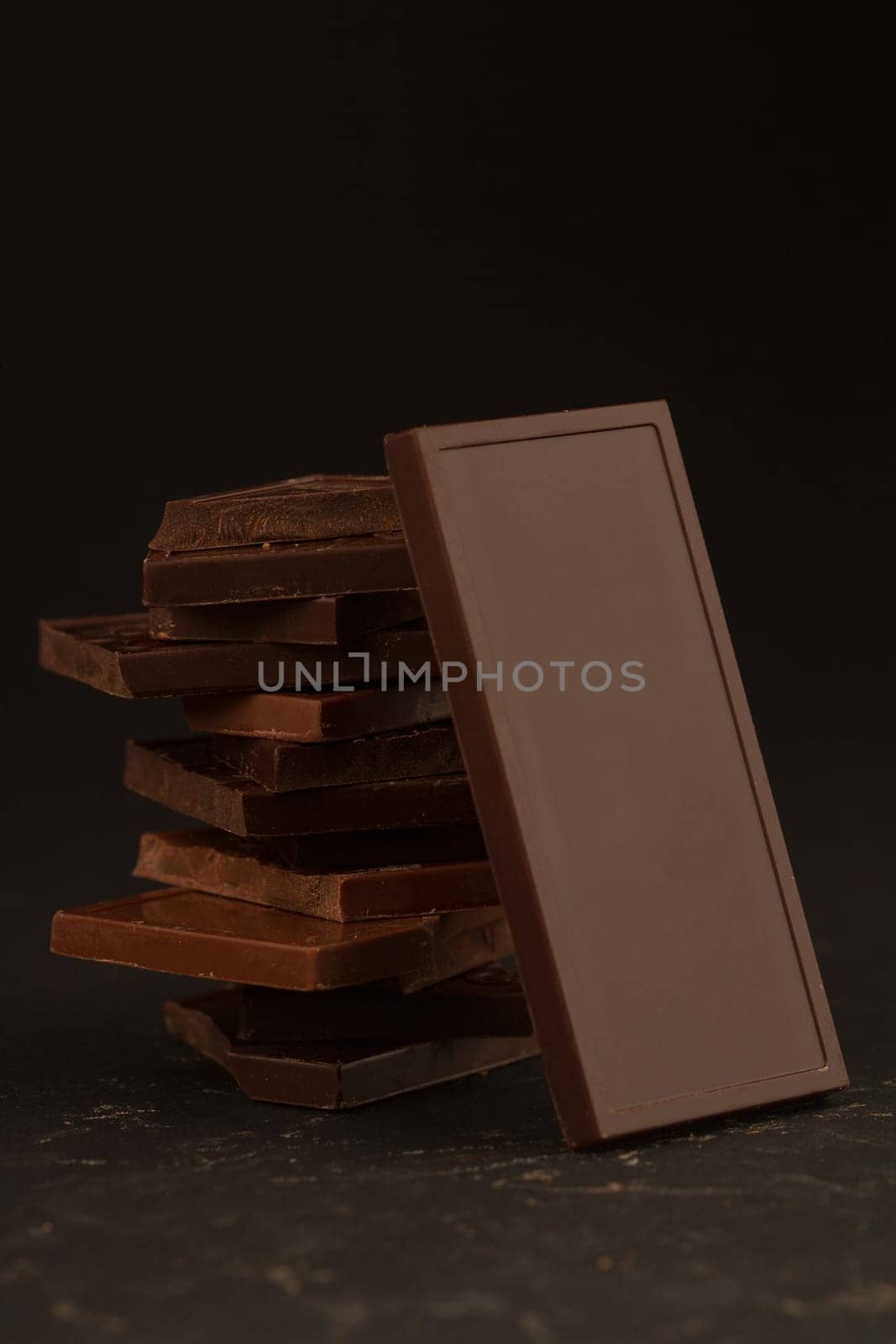 Front view of square shaped chocolate pieces isolated on dark background