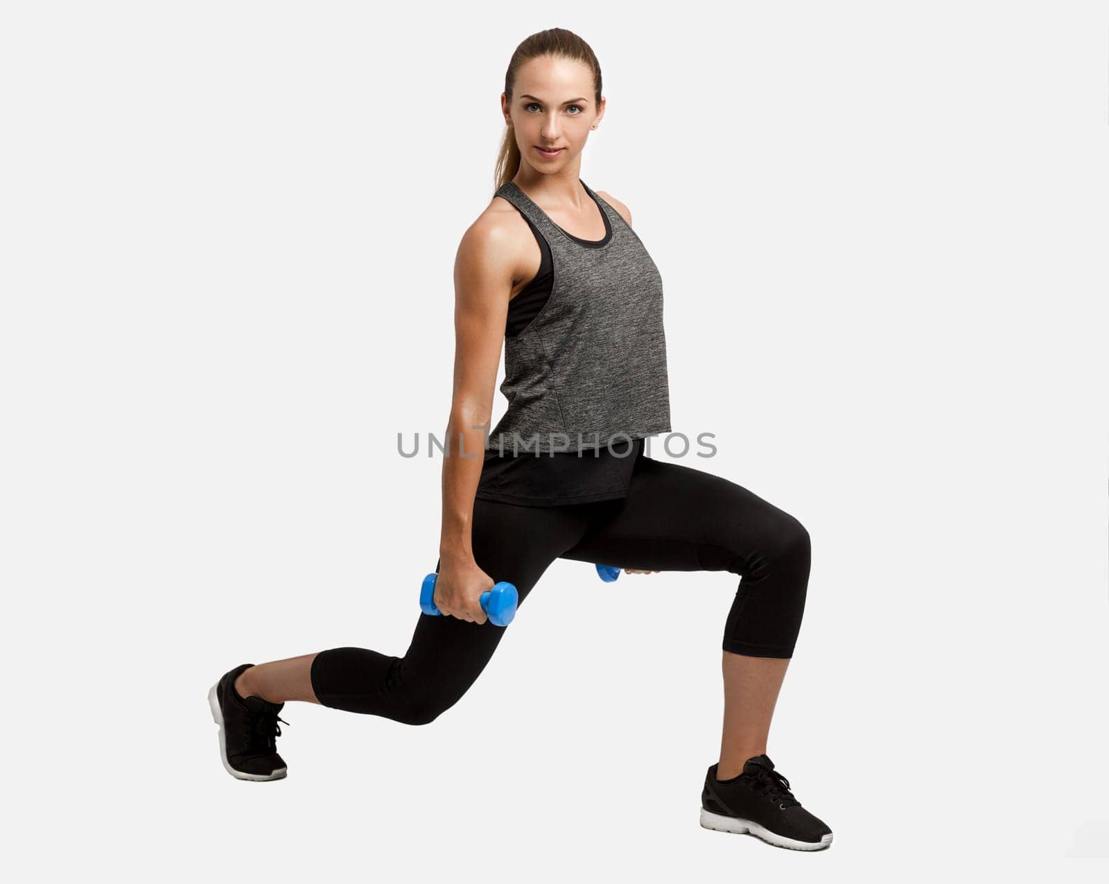 Young fitness woman making exercises with dumbbells