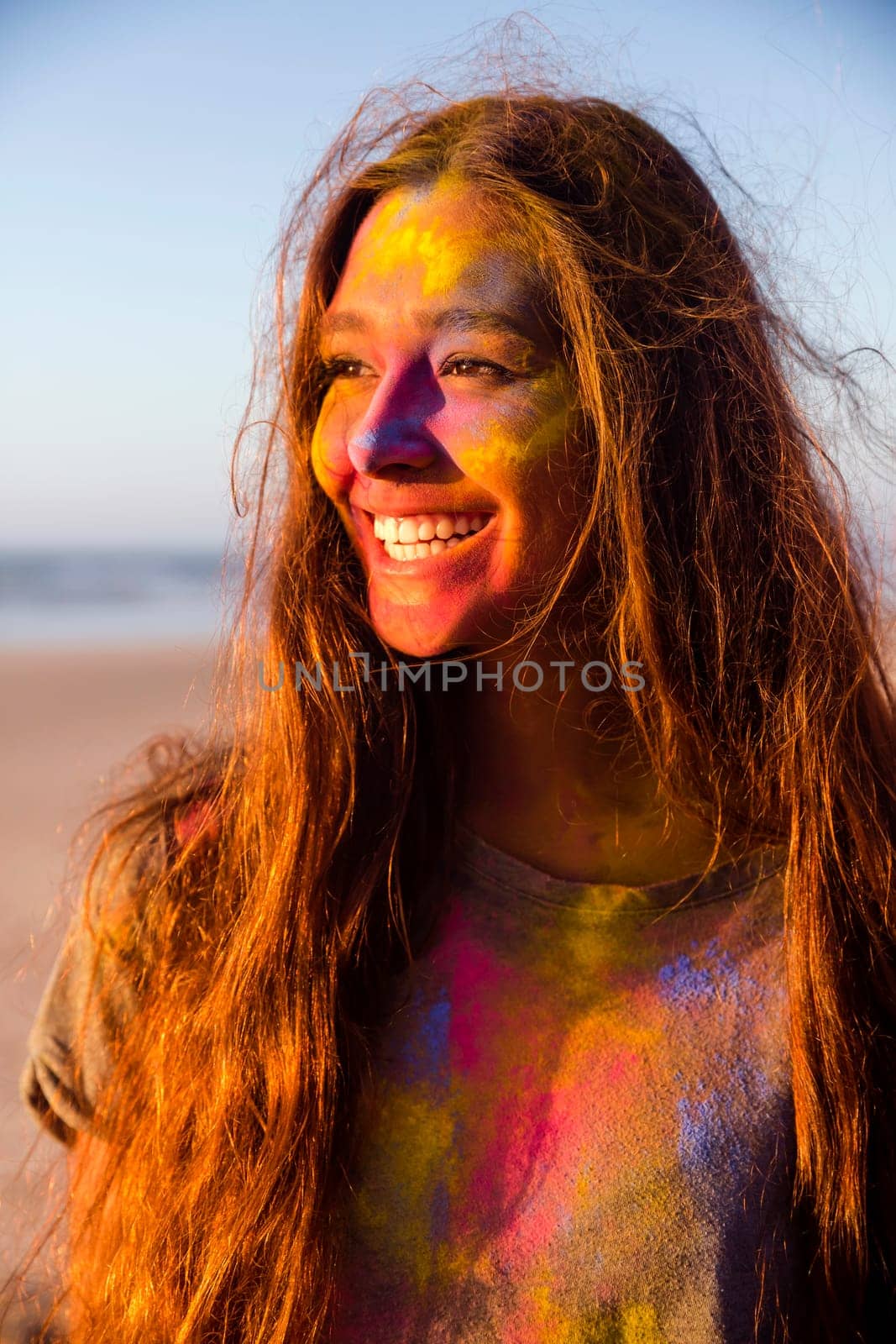 Portrait of a beautiful girl full of colored powder all over the body