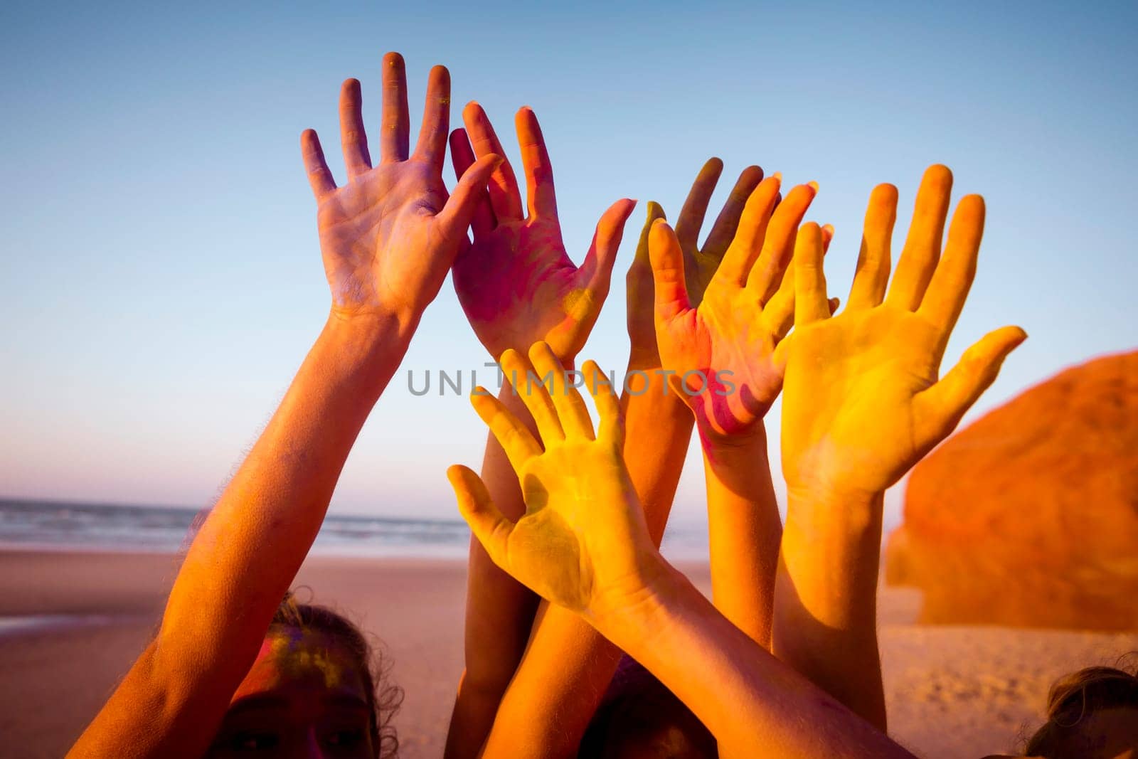 Teenagers playing with colored powder on the beach
