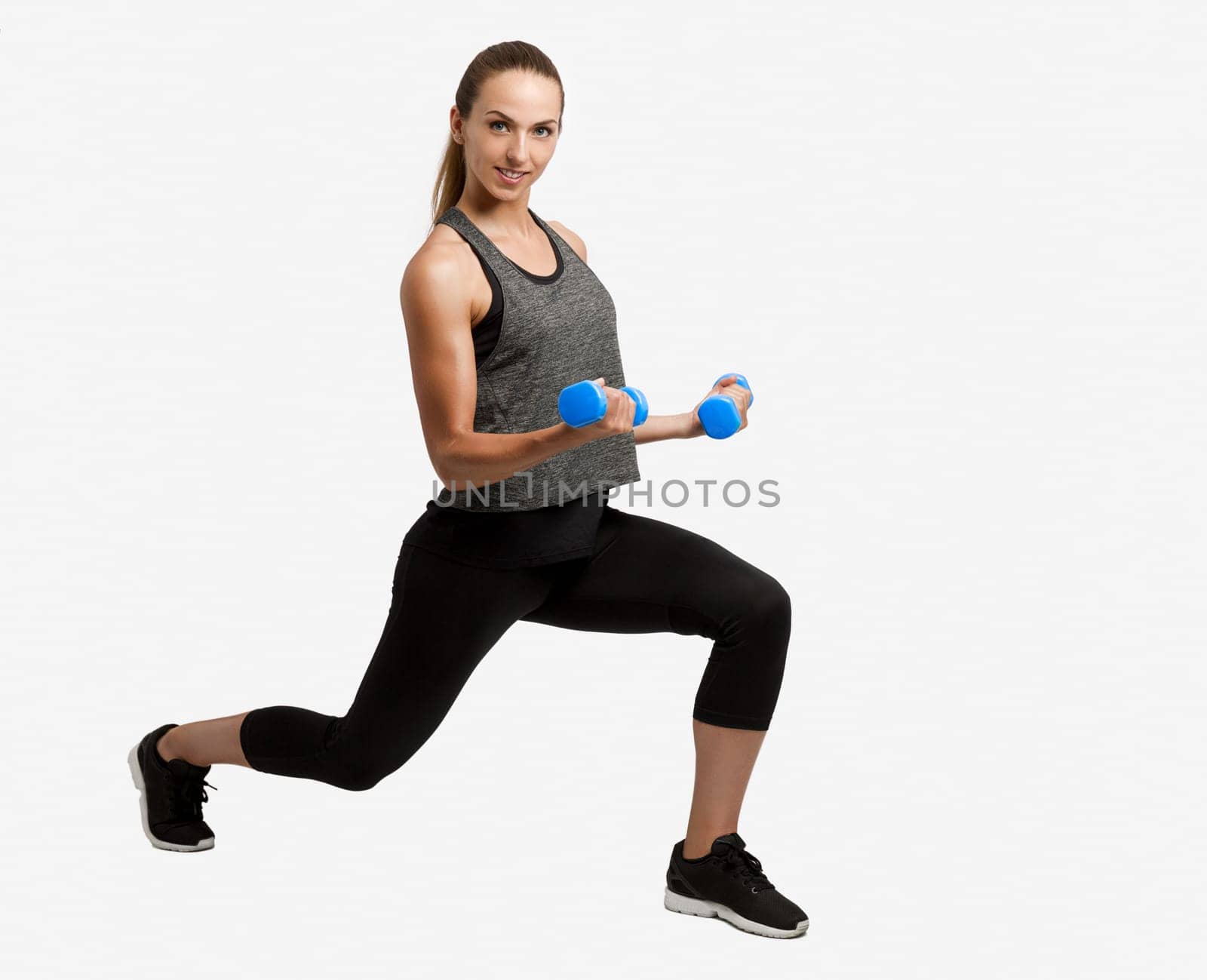 Young fitness woman making exercises with dumbbells