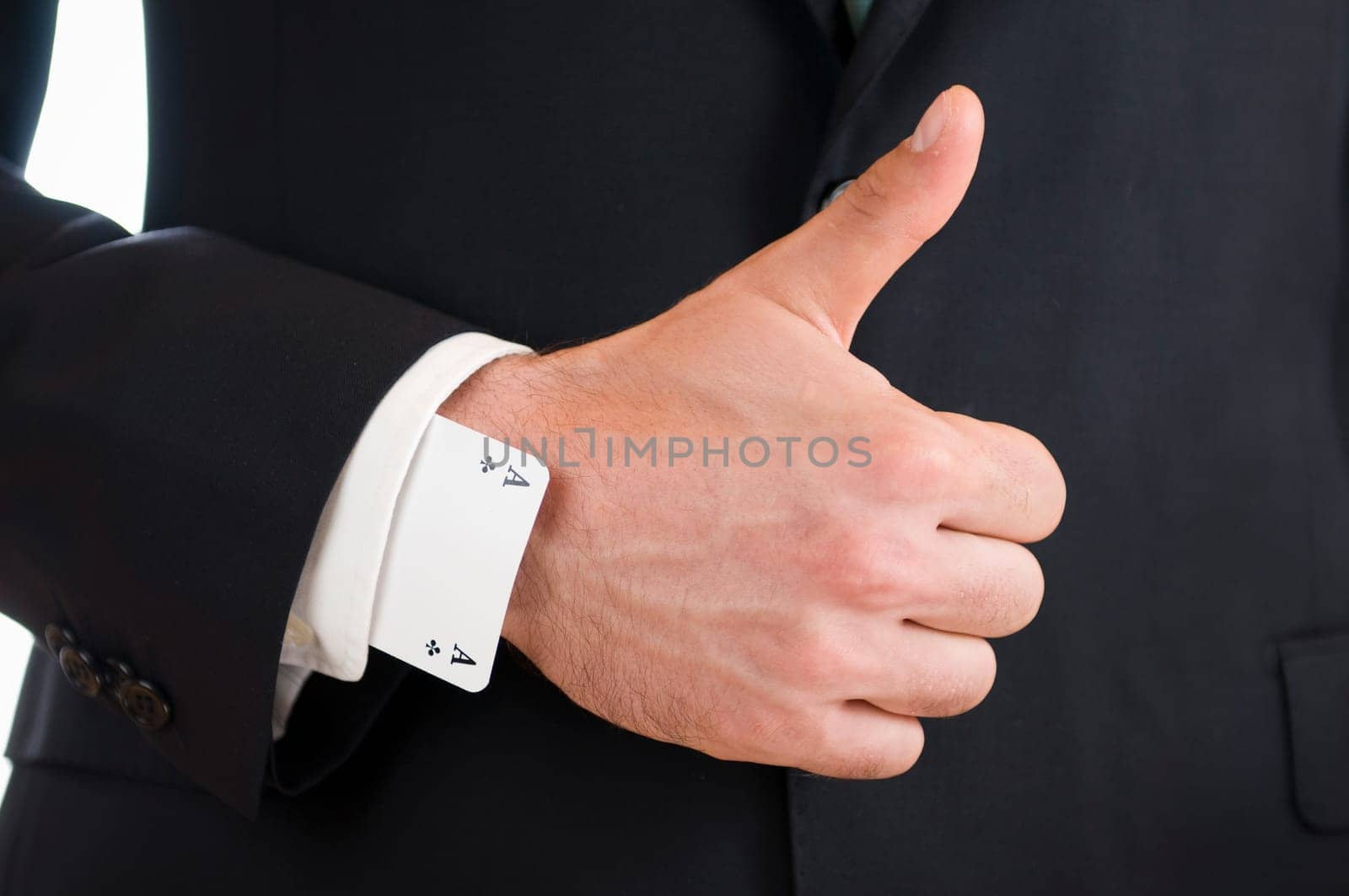 Close-up of a male hand pointing the thumb up with an ace playing card up his sleeve.