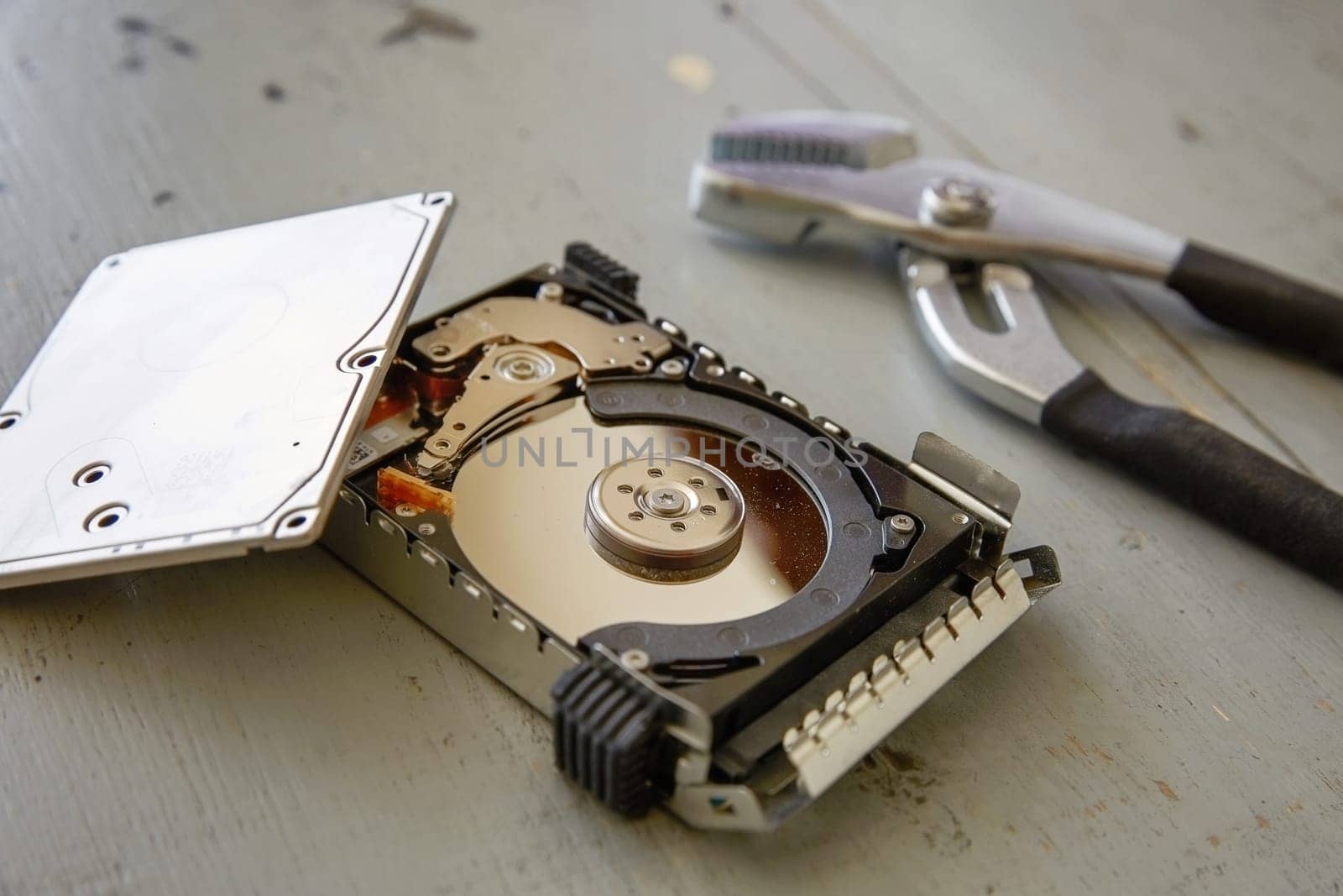 Broken and Destroyed Hard Drive Disk on Wooden Table.