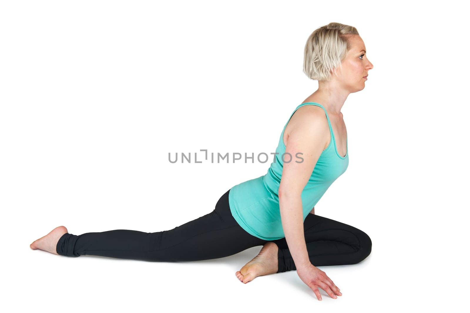 Young woman on a white background in half a spagath. The right leg stretched backwards  the left foot under the center of the body.