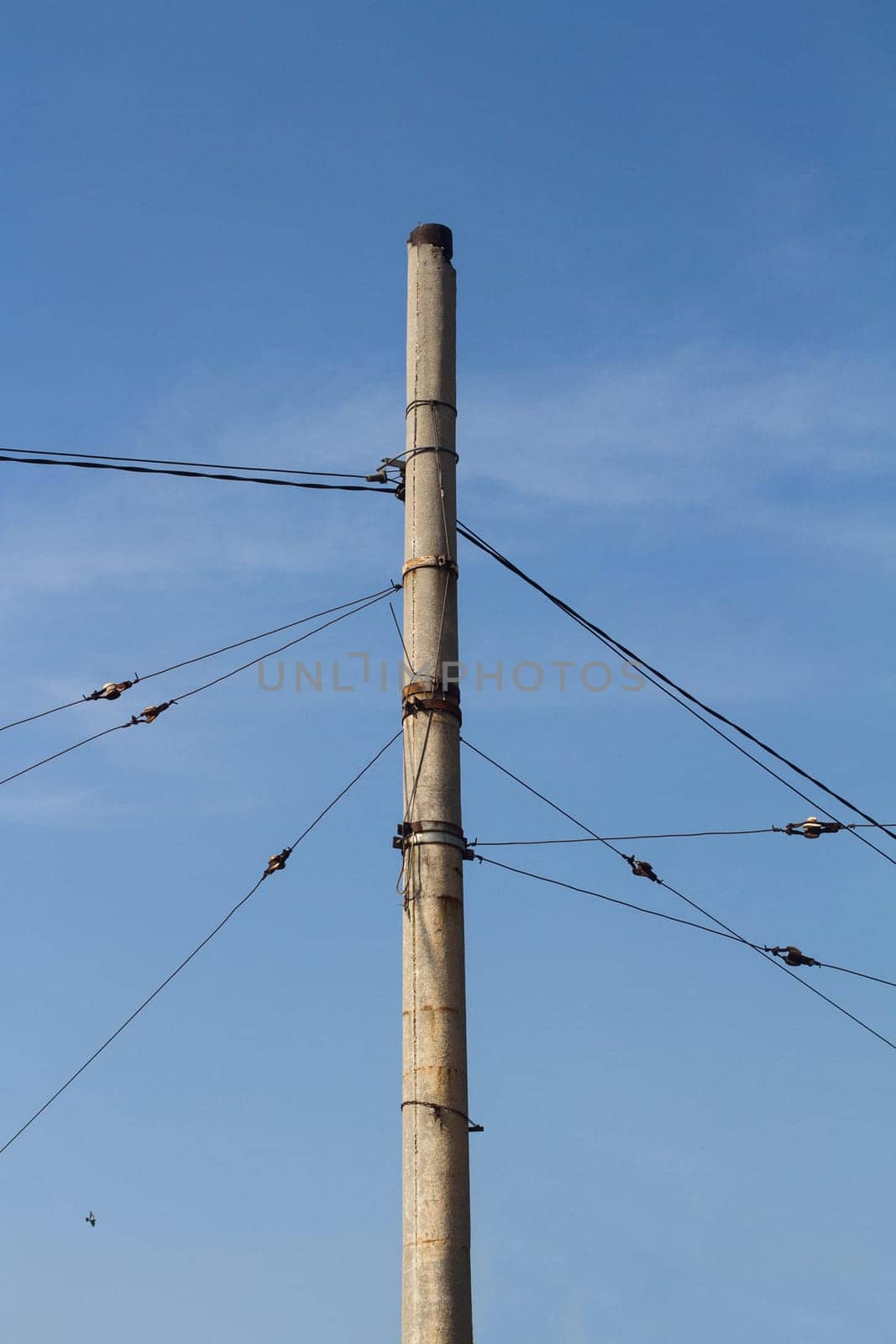 Vertical photo of concrete pillar anchored with steel cables