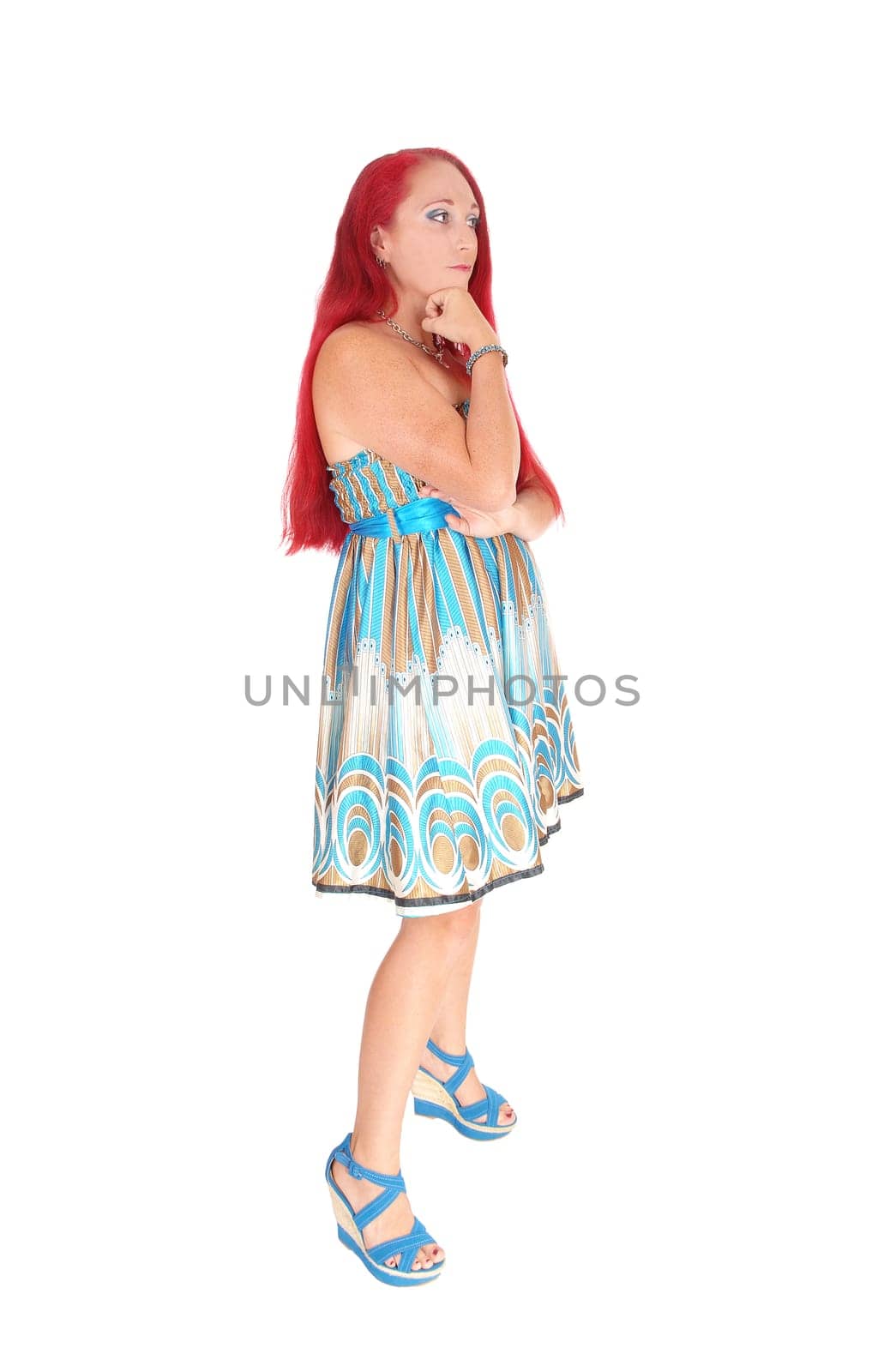 A portrait image of a woman in her thirties, holding her hand under her.chin with long red hair, isolated for white background..