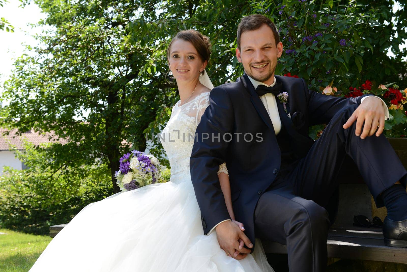 Young bridal couple sits in the park on a park bench