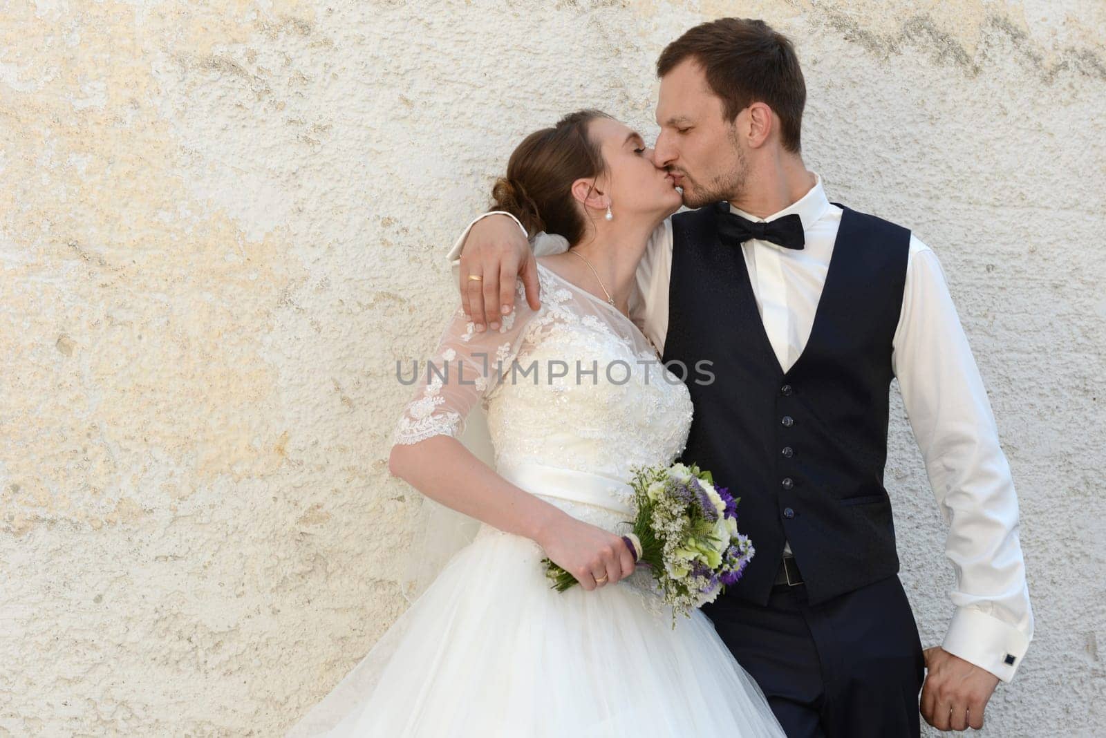 Bridal couple in love kisses