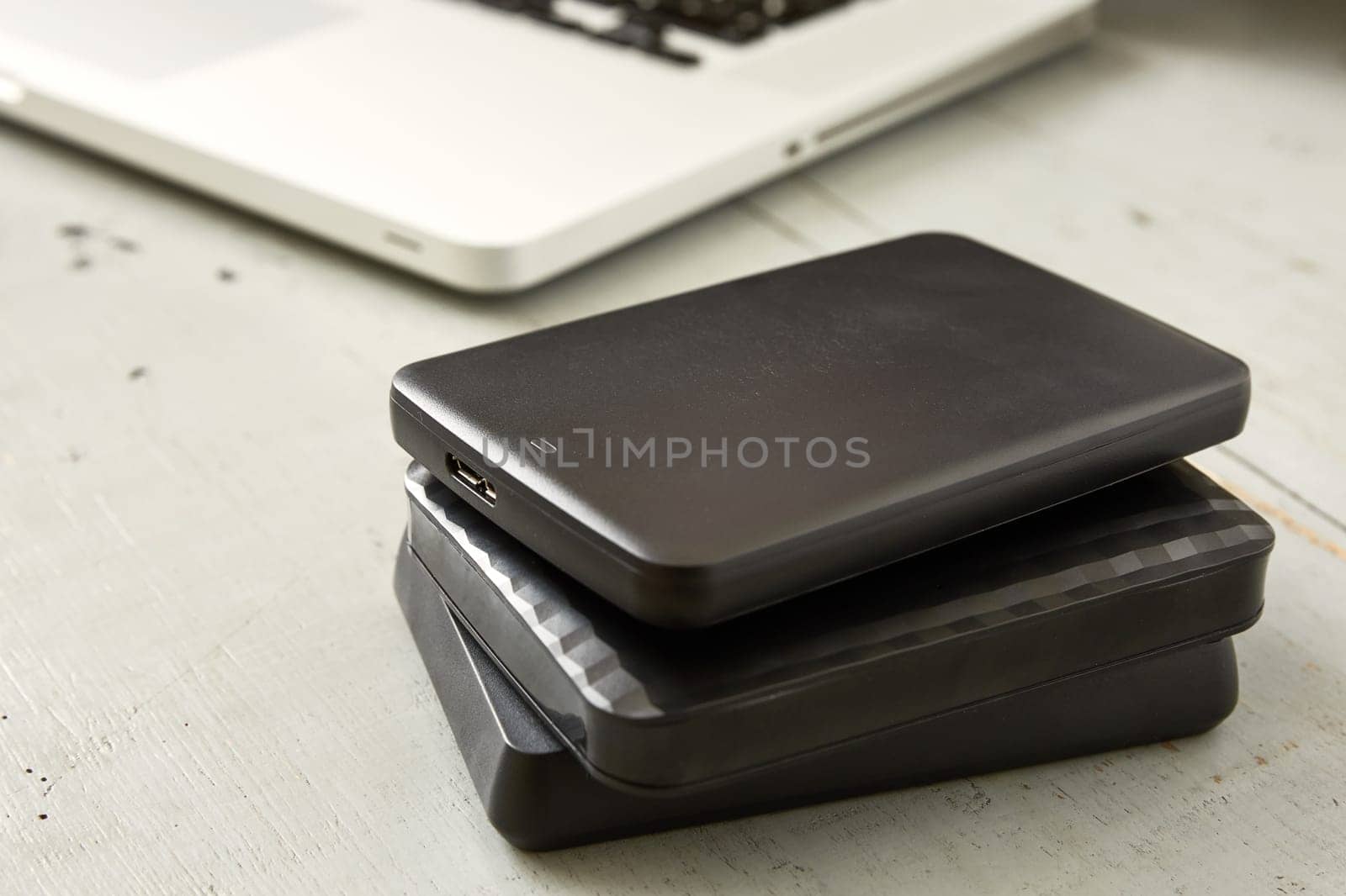External Hard Disks and Laptop Keyboard on Wooden Table.