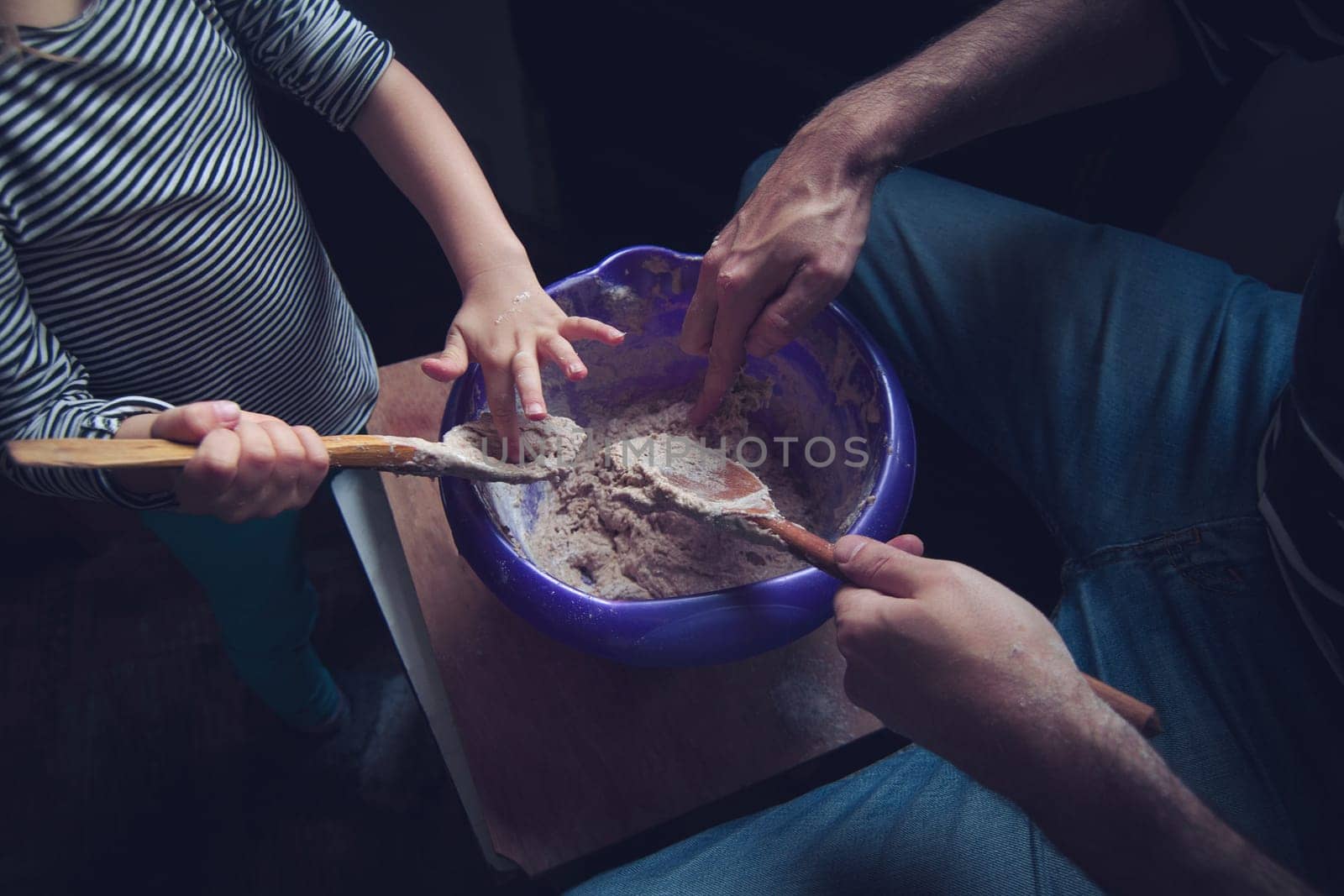 Top view of father and daughter working the dough of a bread together