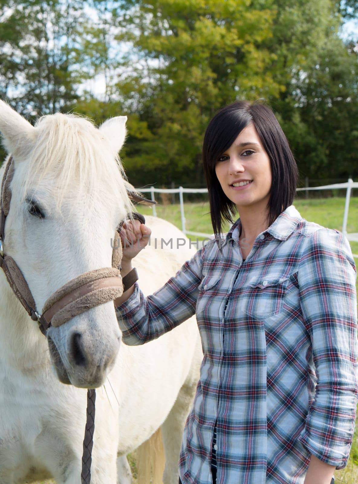 young rider  brunette girl with her white horse