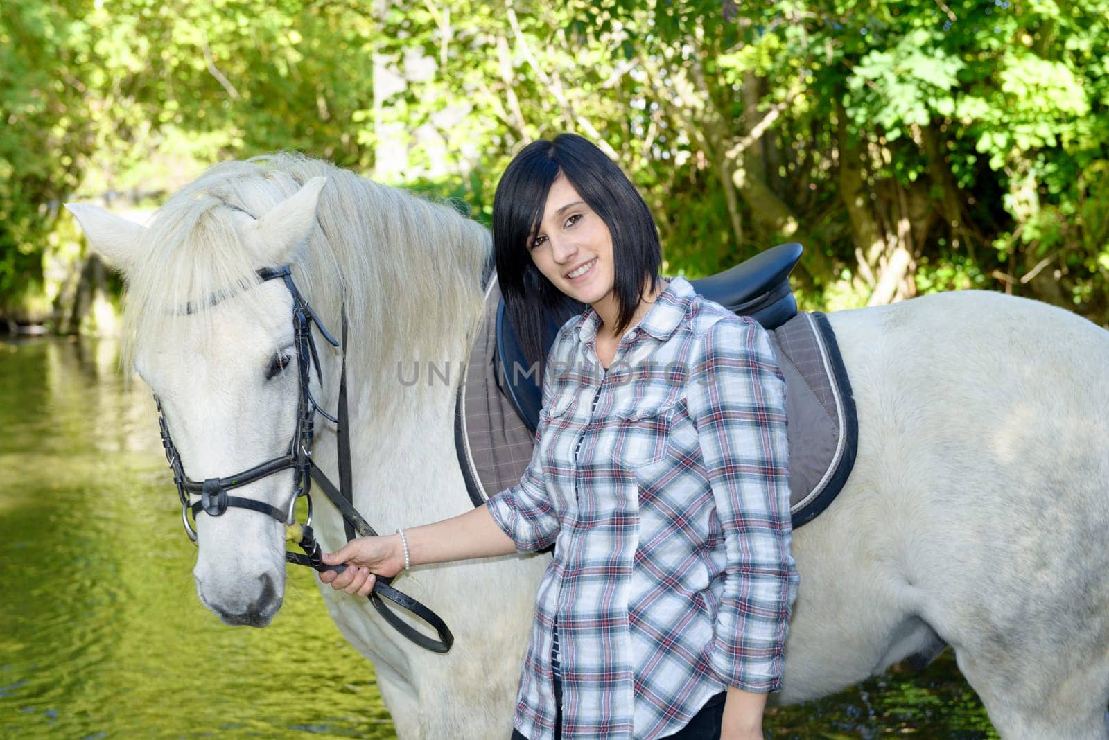 young rider  brunette girl with her white horse