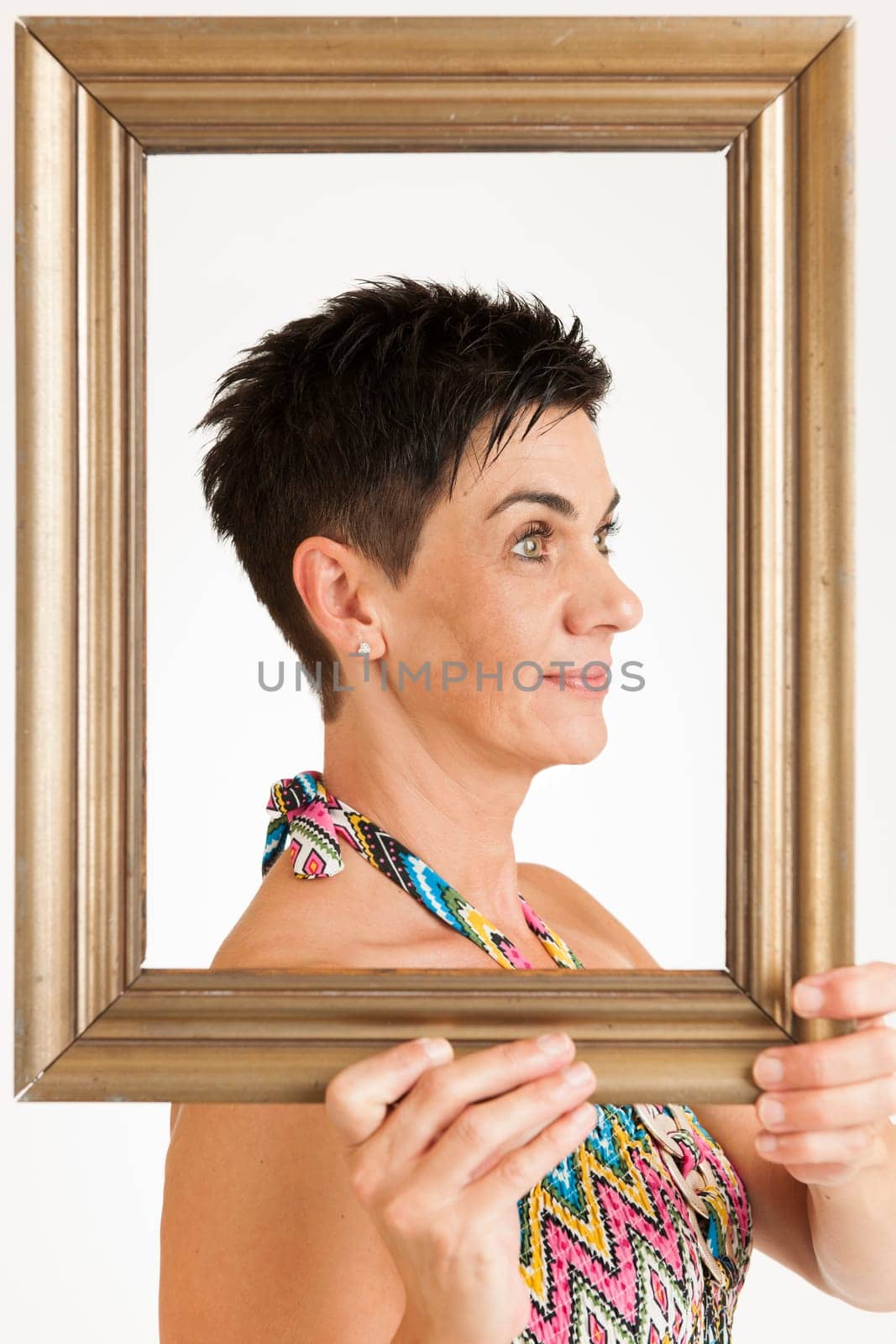 Upper body view of a middle-aged black-haired woman with gilded picture frames against a white background
