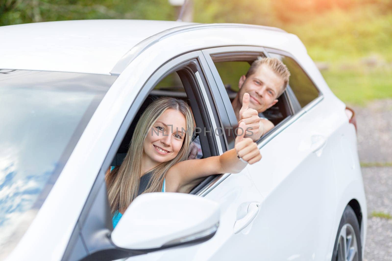 Young happy people enjoying a roadtrip in the car