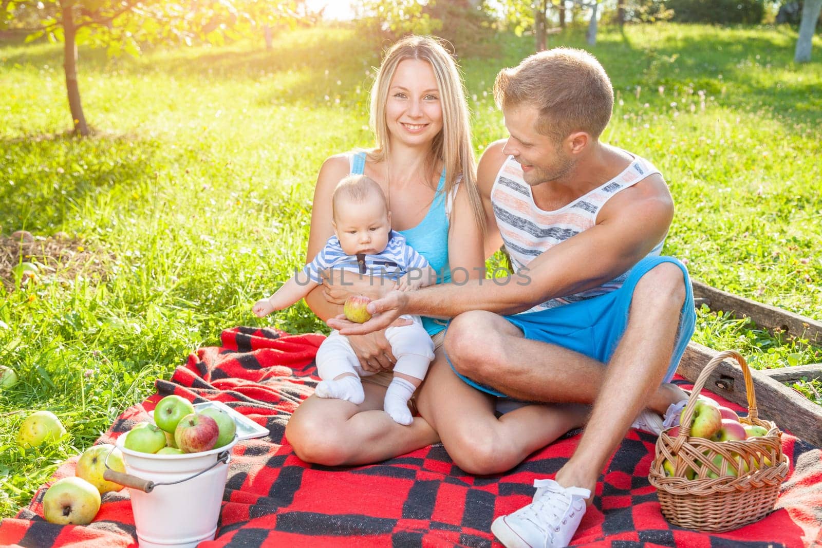 Happy family enjoying a picnic with their baby outdoors