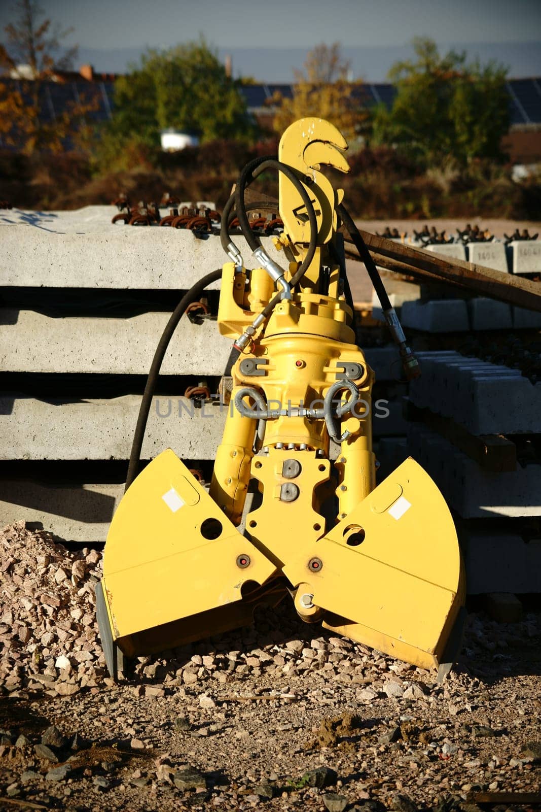 The close-up of an excavator shovel next to tools and materials.