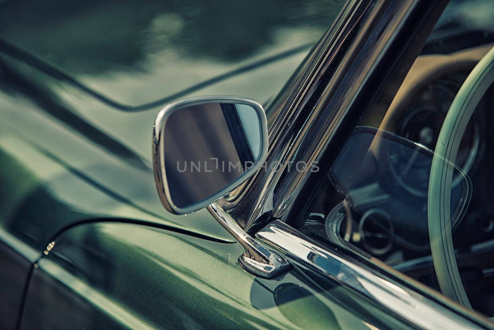 close up on rear view mirror on greenv intage car.