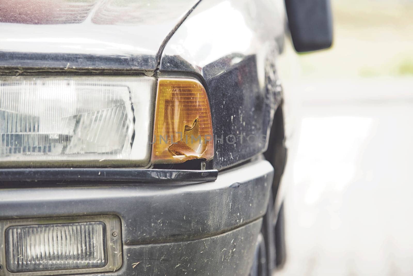close up on broken front light in the blue car