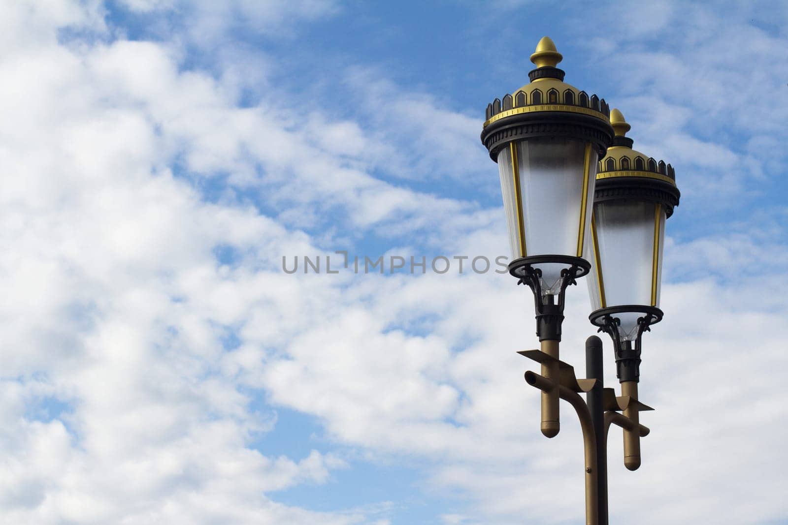 Classical design public illumination lights on blue sky with clouds
