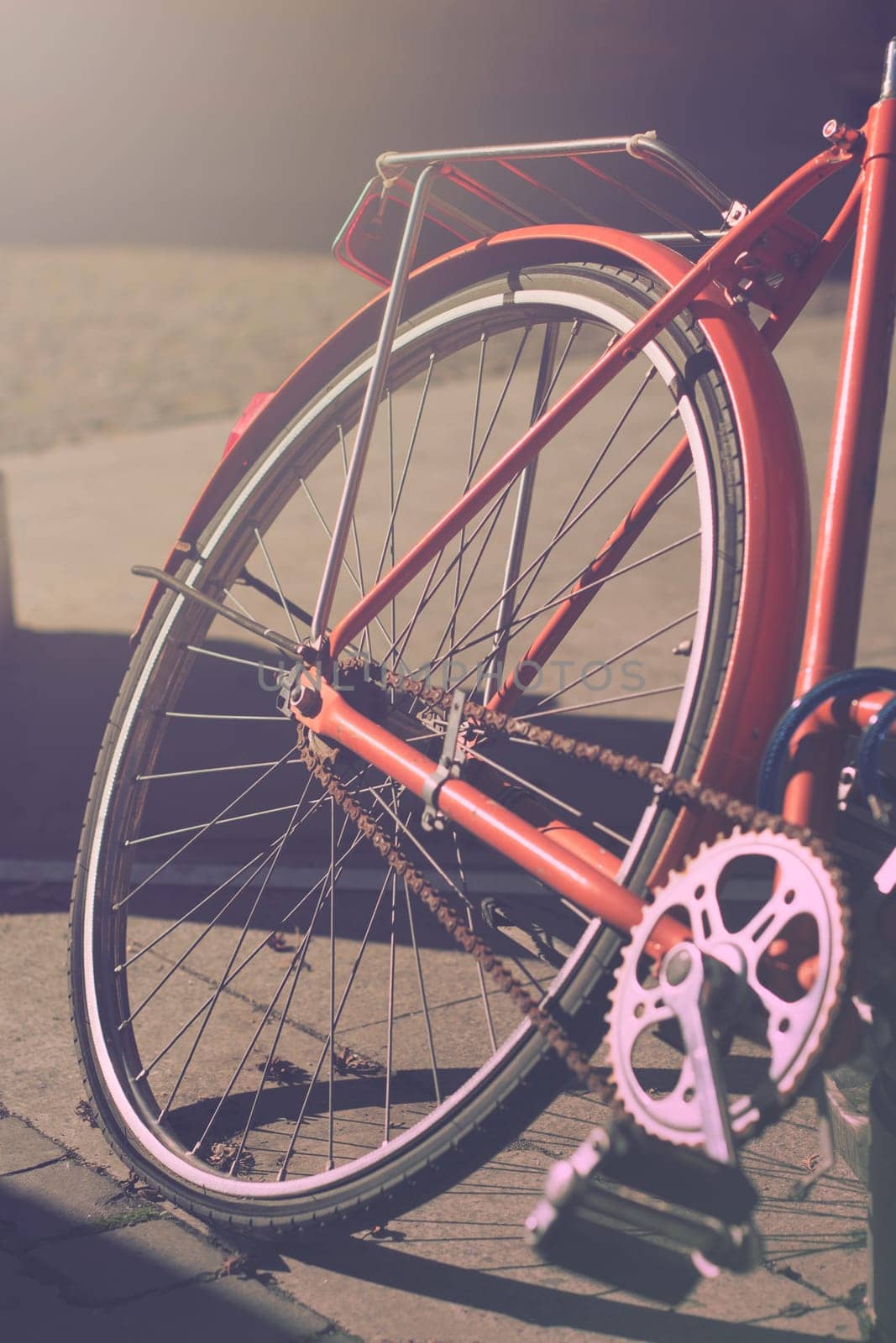 Vertical close up of an orange city bike in the morning light