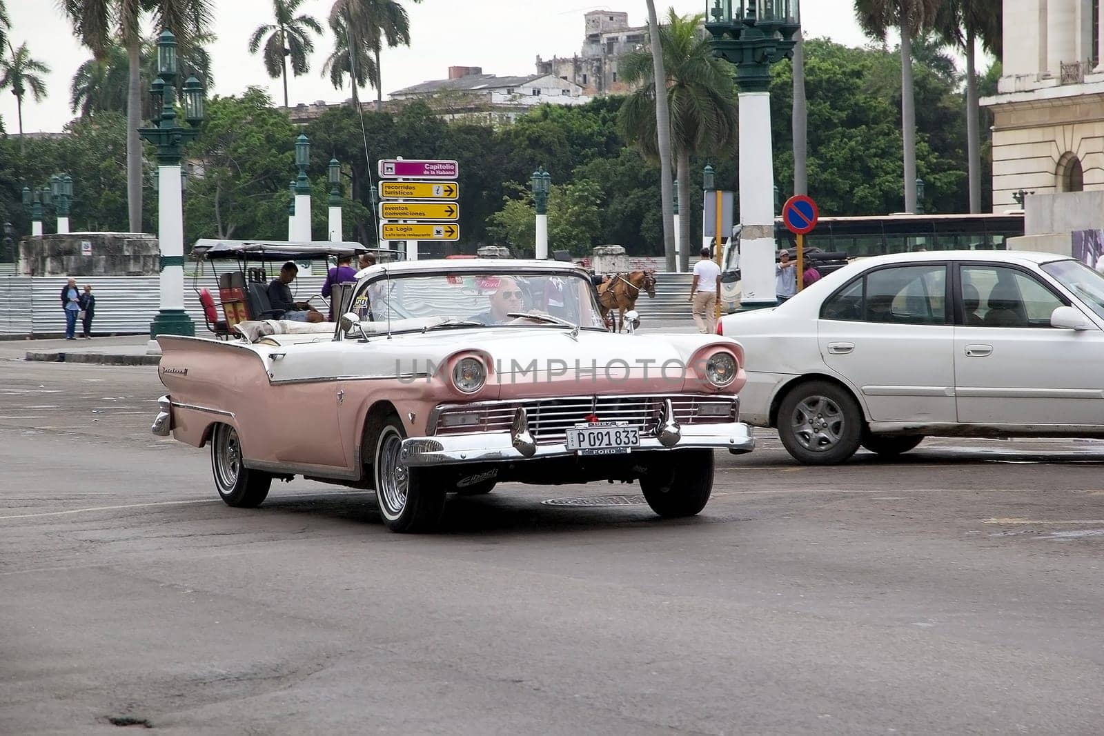 Old classic american cars drived along the street at the Havana old town