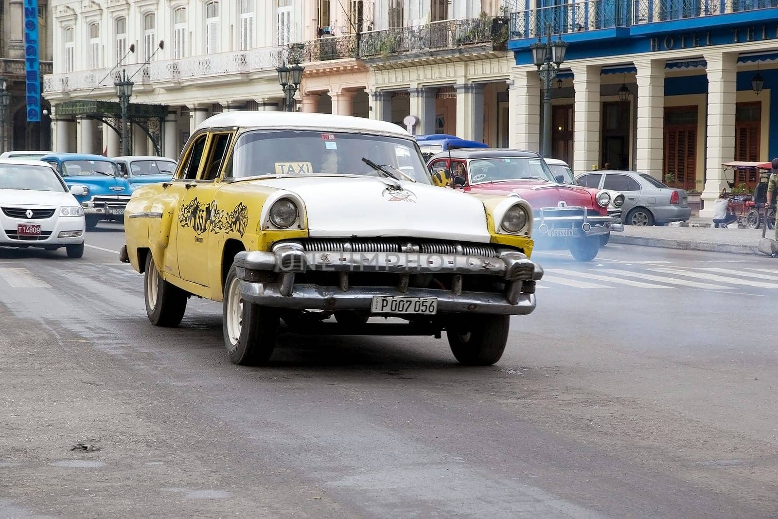 Old classic american cars drived along the street at the Havana old town