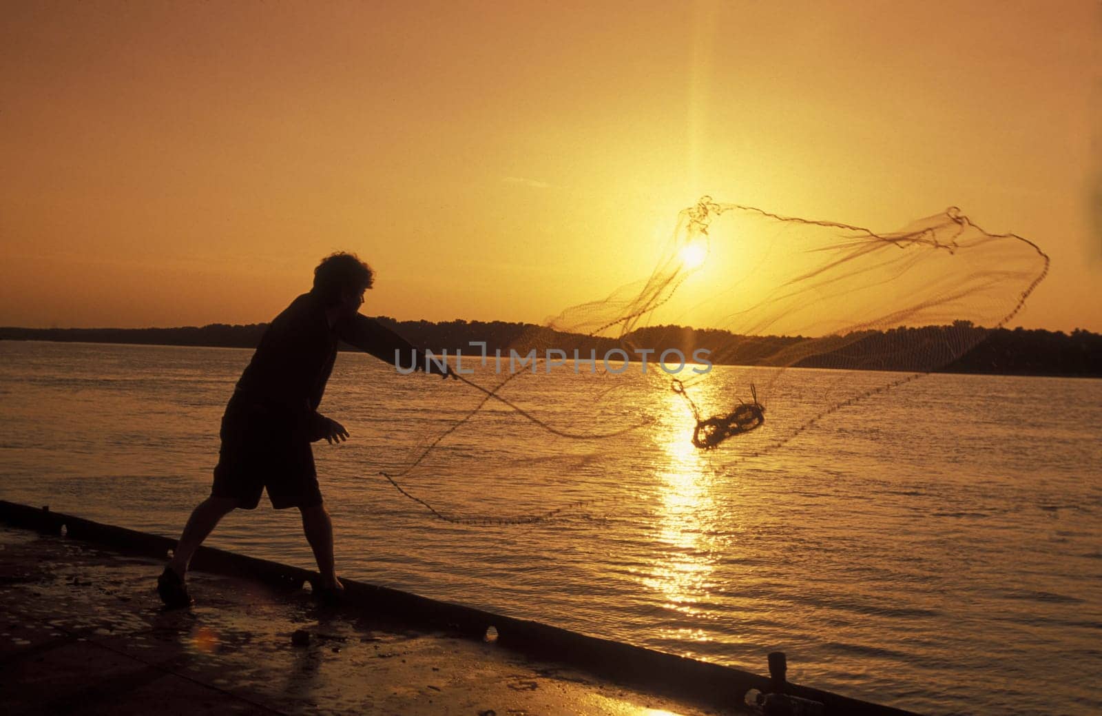 a fishing men at the river Danube in the city of Ruse on the border to romania in Bulgaria in east Europe.