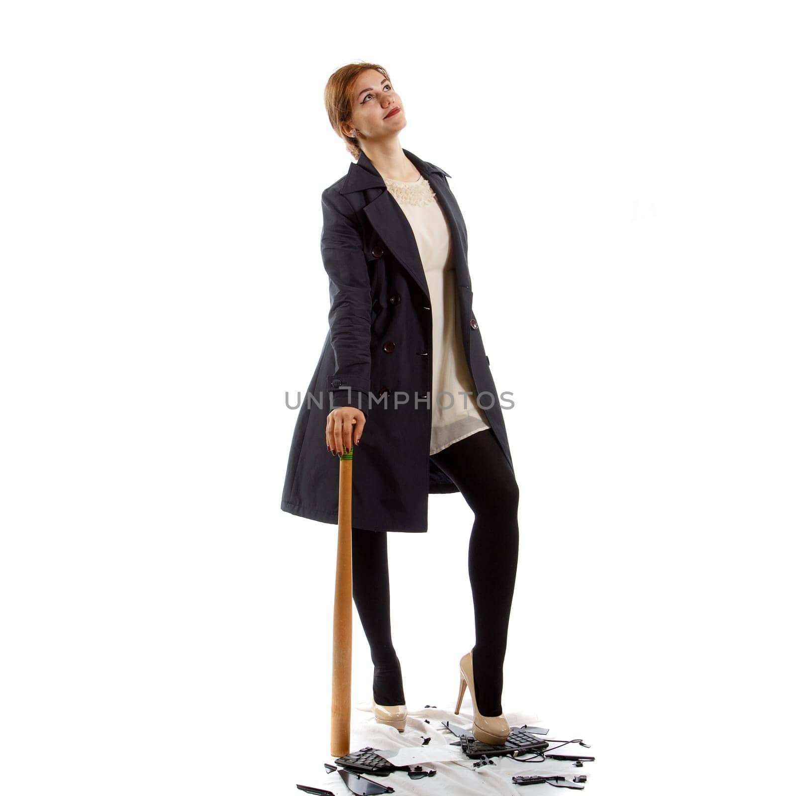 A young lady with a baseball bat standing on a broken keyboard