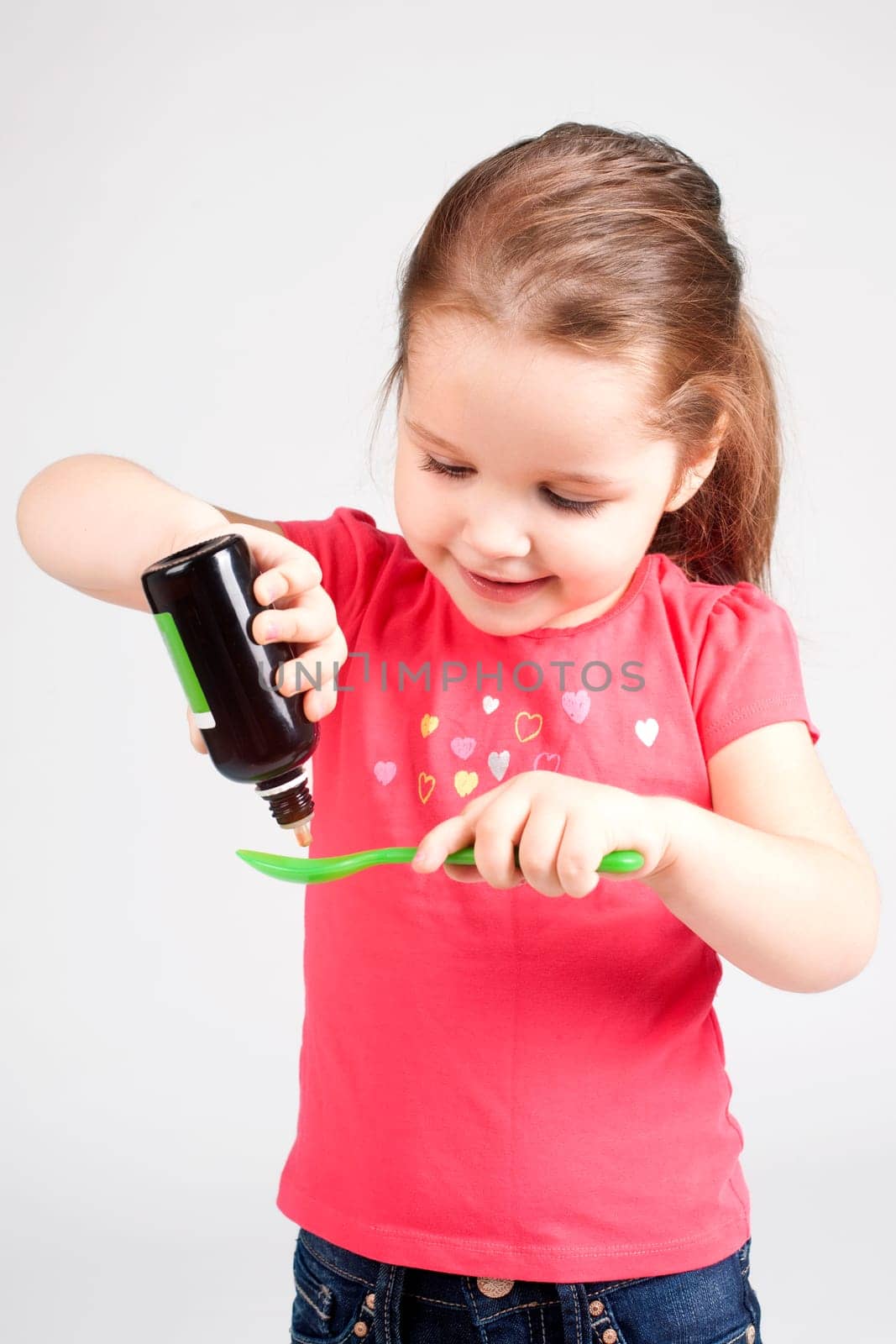 Cute Baby Girl Drinking Medicine Syrup - Stock image