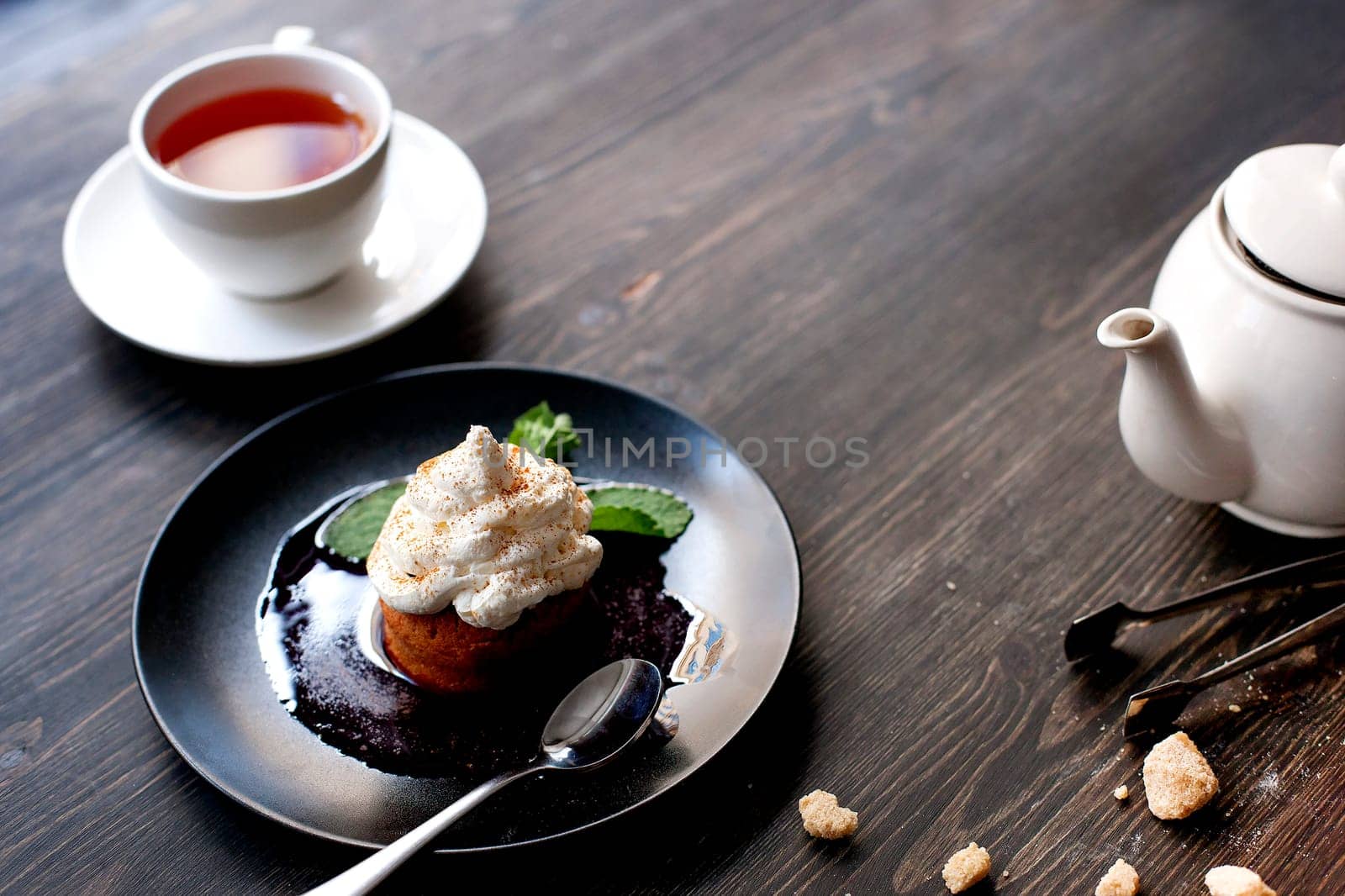 Breakfast time . Tea and cake with cream, garnished with mint leaves.