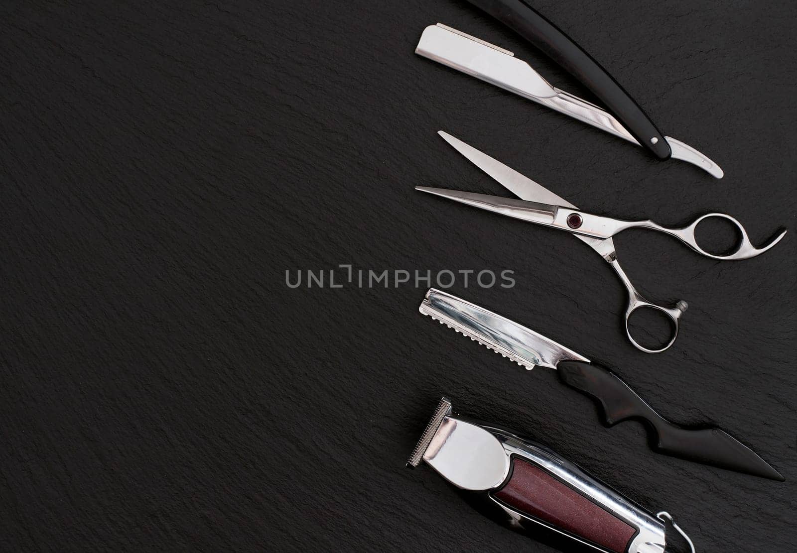 Barber shop equipment on Black background with place for text.  Professional hairdressing tools. Comb, scissor, clippers and hair trimmer isolated.