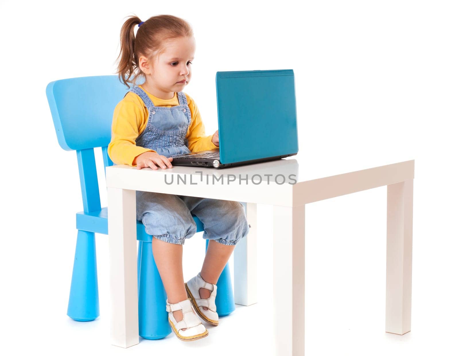 Portrait of a cute little girl using laptop. Horizontal shot. Isolated on white.