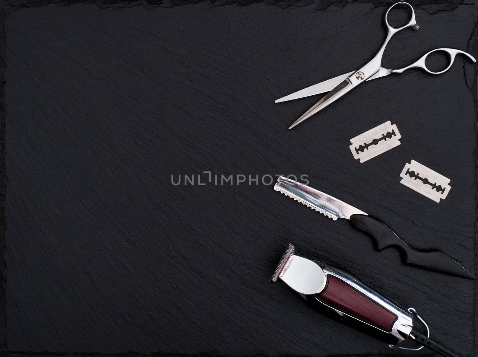 Barber shop equipment on Black background with place for text.  Professional hairdressing tools. Comb, scissor, clippers and hair trimmer isolated.