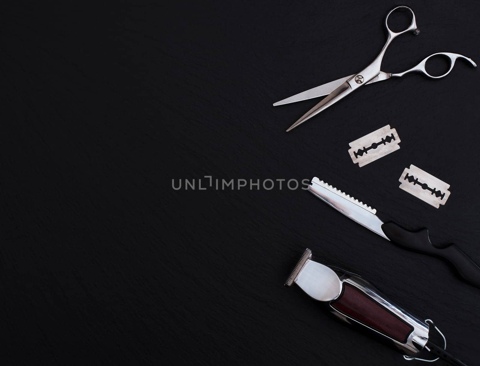 Barber shop equipment on Black background with place for text.  Professional hairdressing tools. Comb, scissor, clippers and hair trimmer isolated.