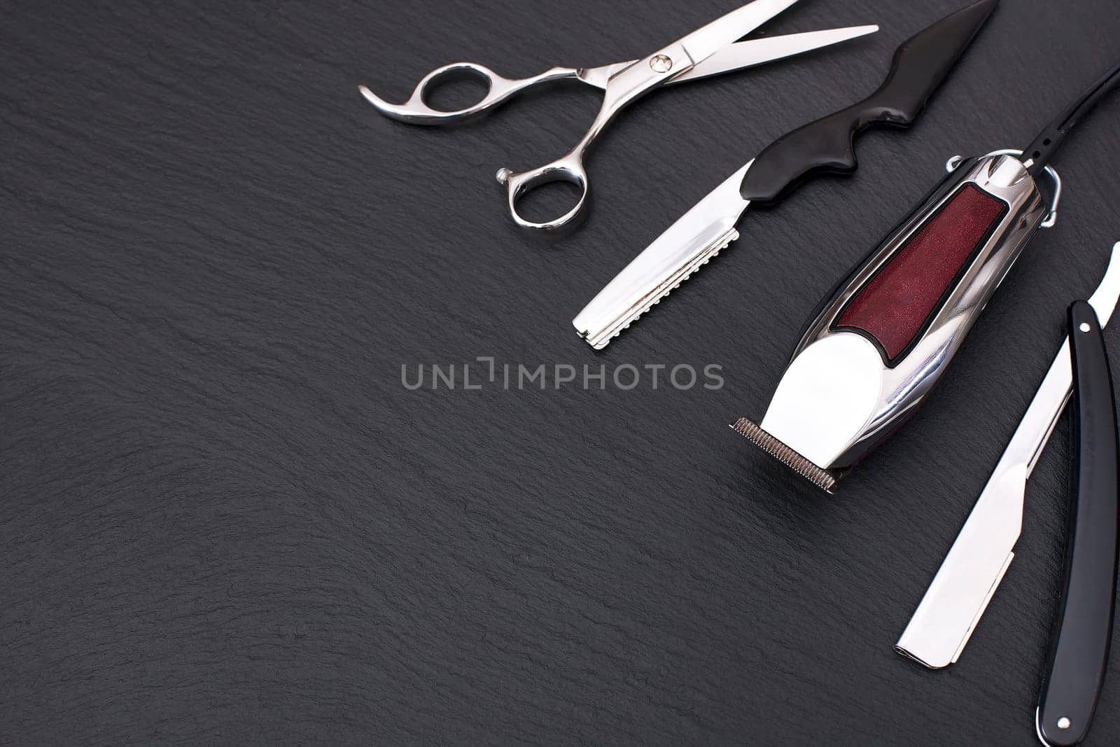 Barber shop equipment on Black background with place for text.  Professional hairdressing tools. Comb, scissor, clippers and hair trimmer isolated.