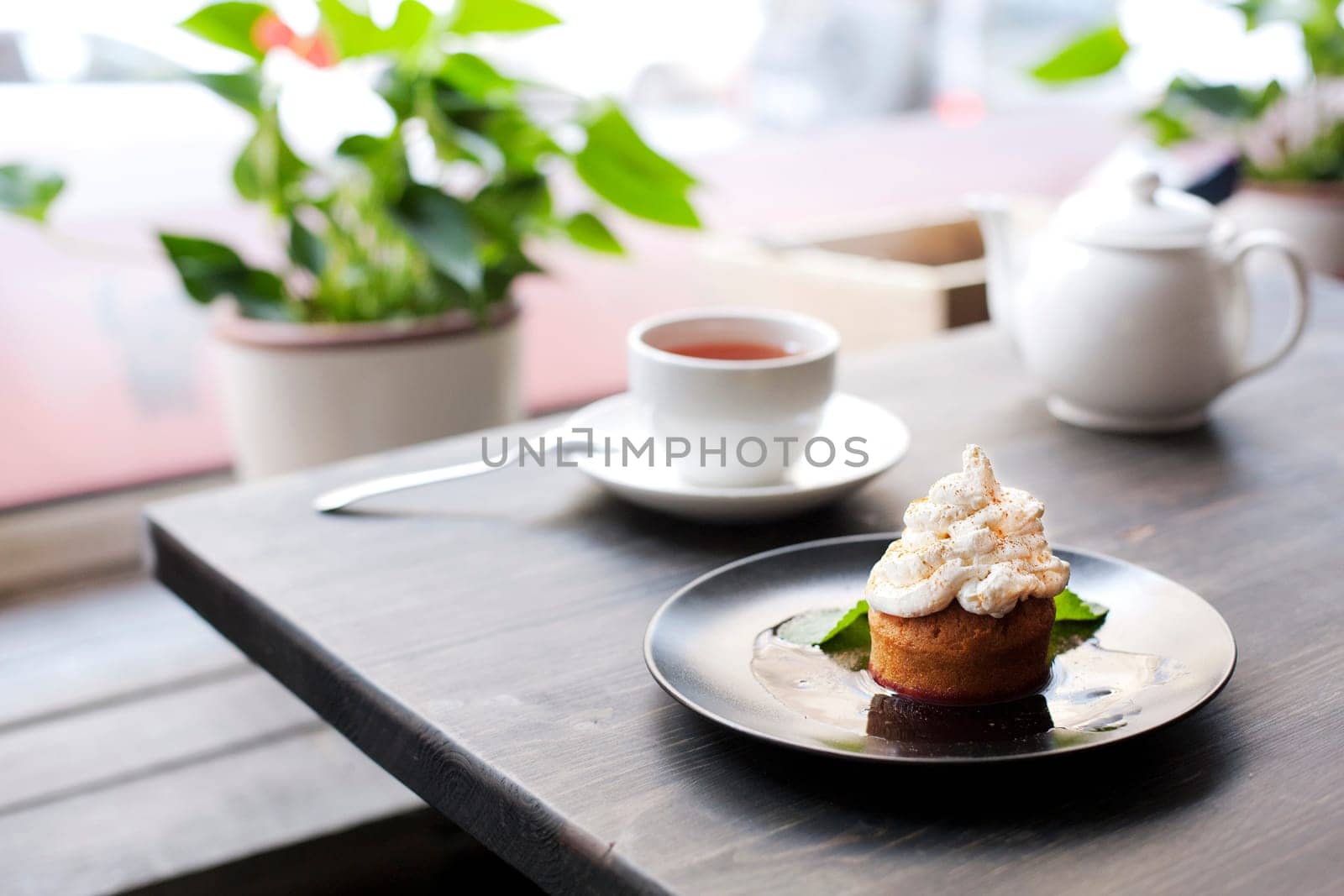 Breakfast time . Tea and cake with cream, garnished with mint leaves