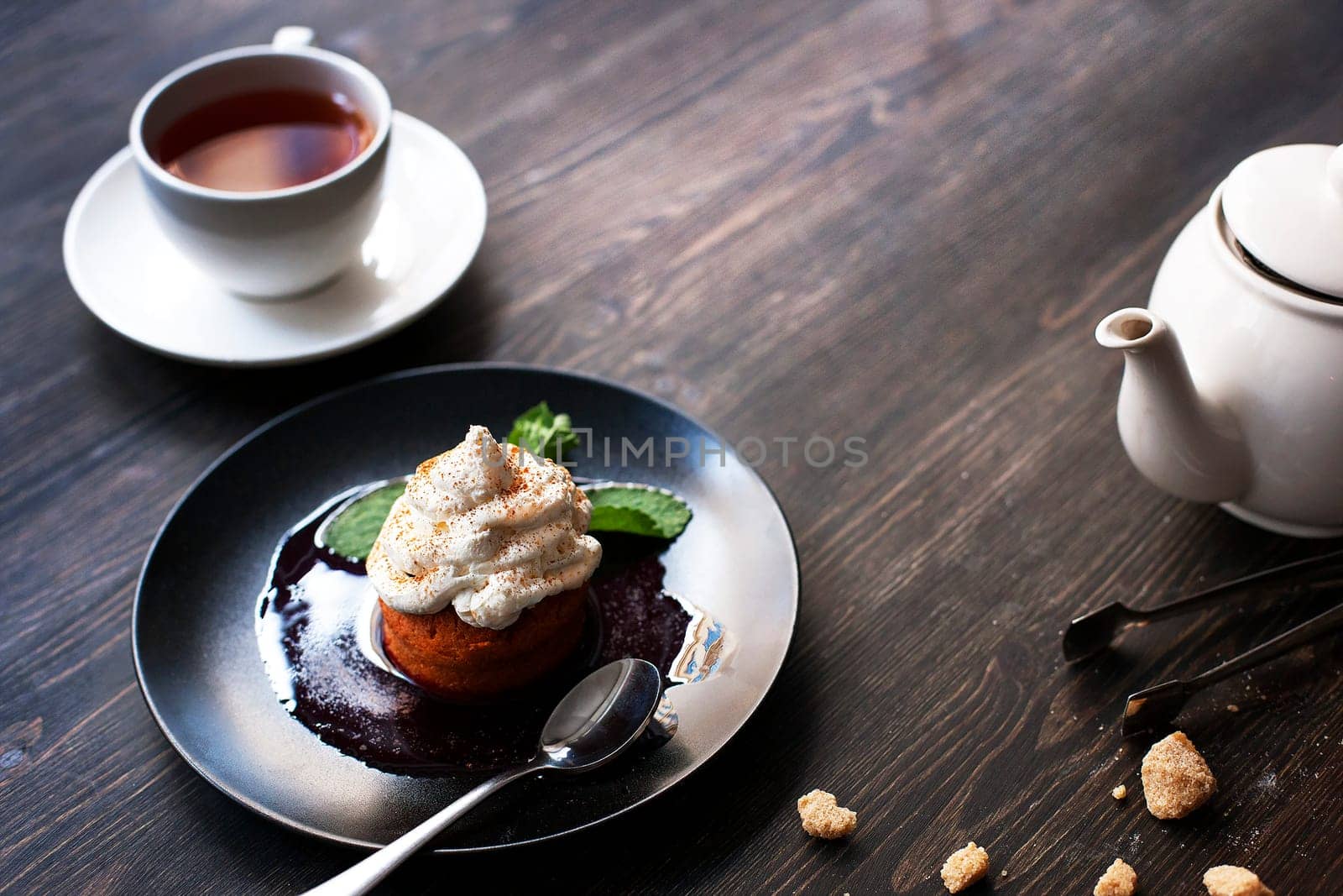 Breakfast time . Tea and cake with cream, garnished with mint leaves.