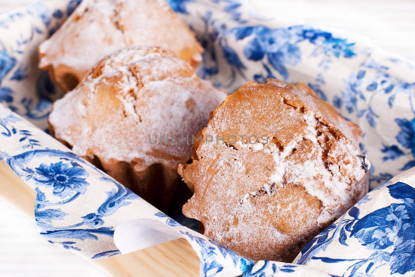 Muffin cakes on a blue tablecloth. Stock image.