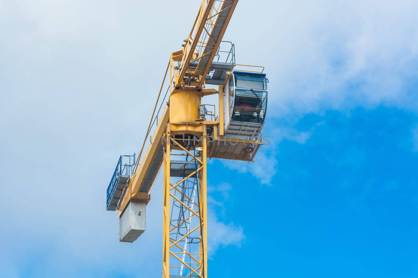 A part of a construction crane photographed against blue sky,space for lettering..