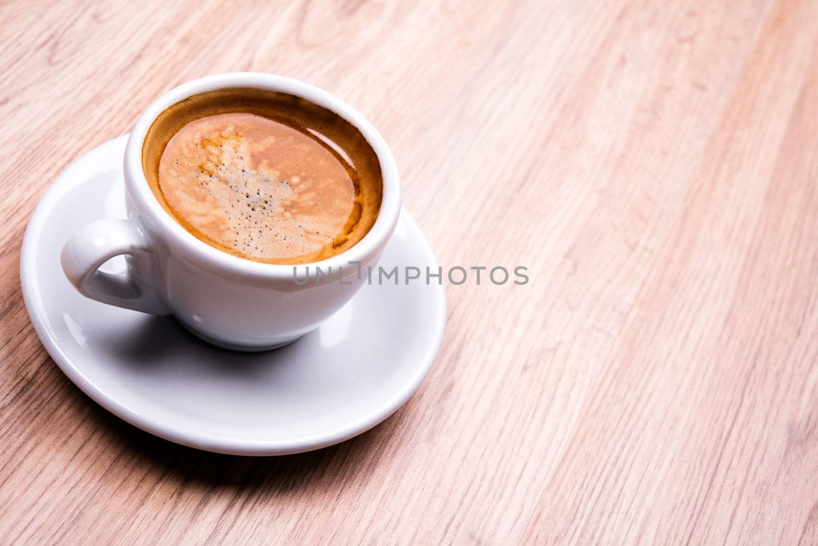 cup of coffee on wooden table from above