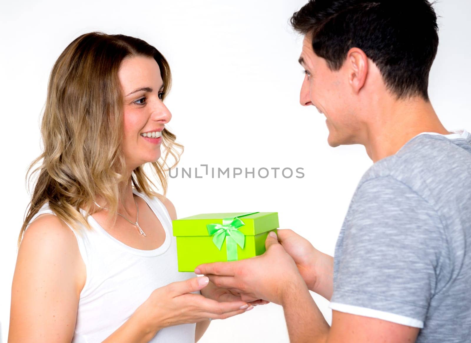 young beautiful couple with gift box in front of white background