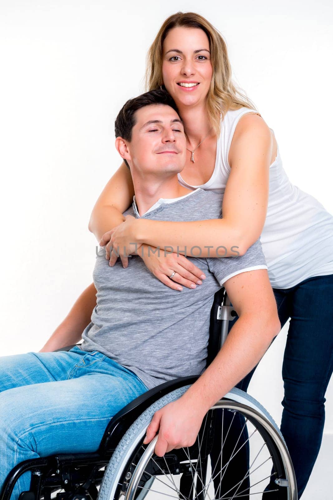 young disabled man in wheelchair and his wife