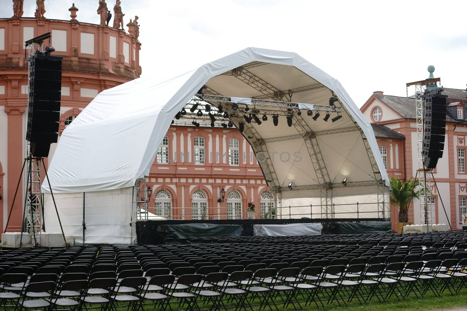 Wiesbaden,Germany - July 14,2016: A concert stage set up with rows of seats for a classical concert on the castle grounds with Schloss Biebrich in the background on July 14,2016 in Wiesbaden.