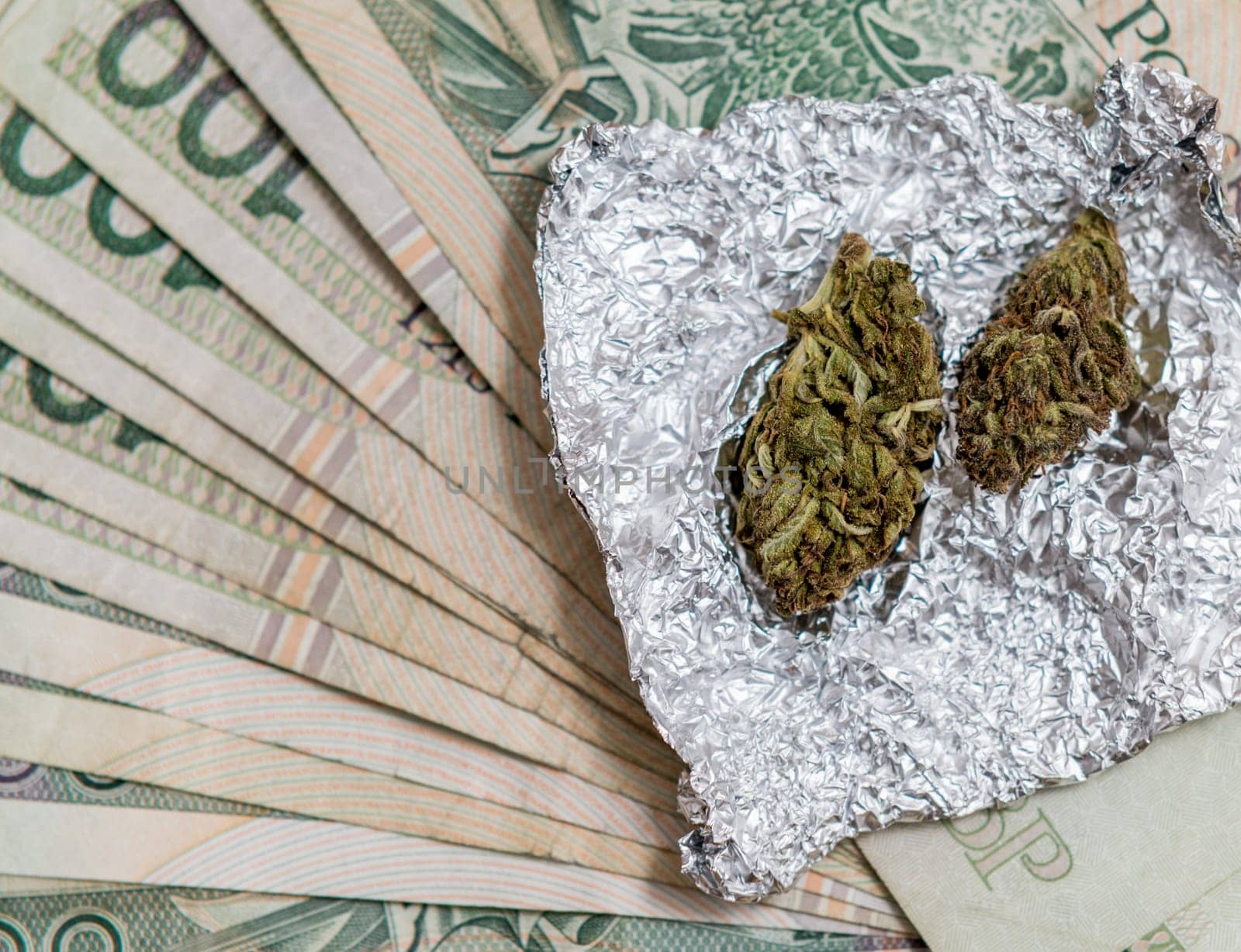 marijuana in tin foil with pipe and polish pln money background