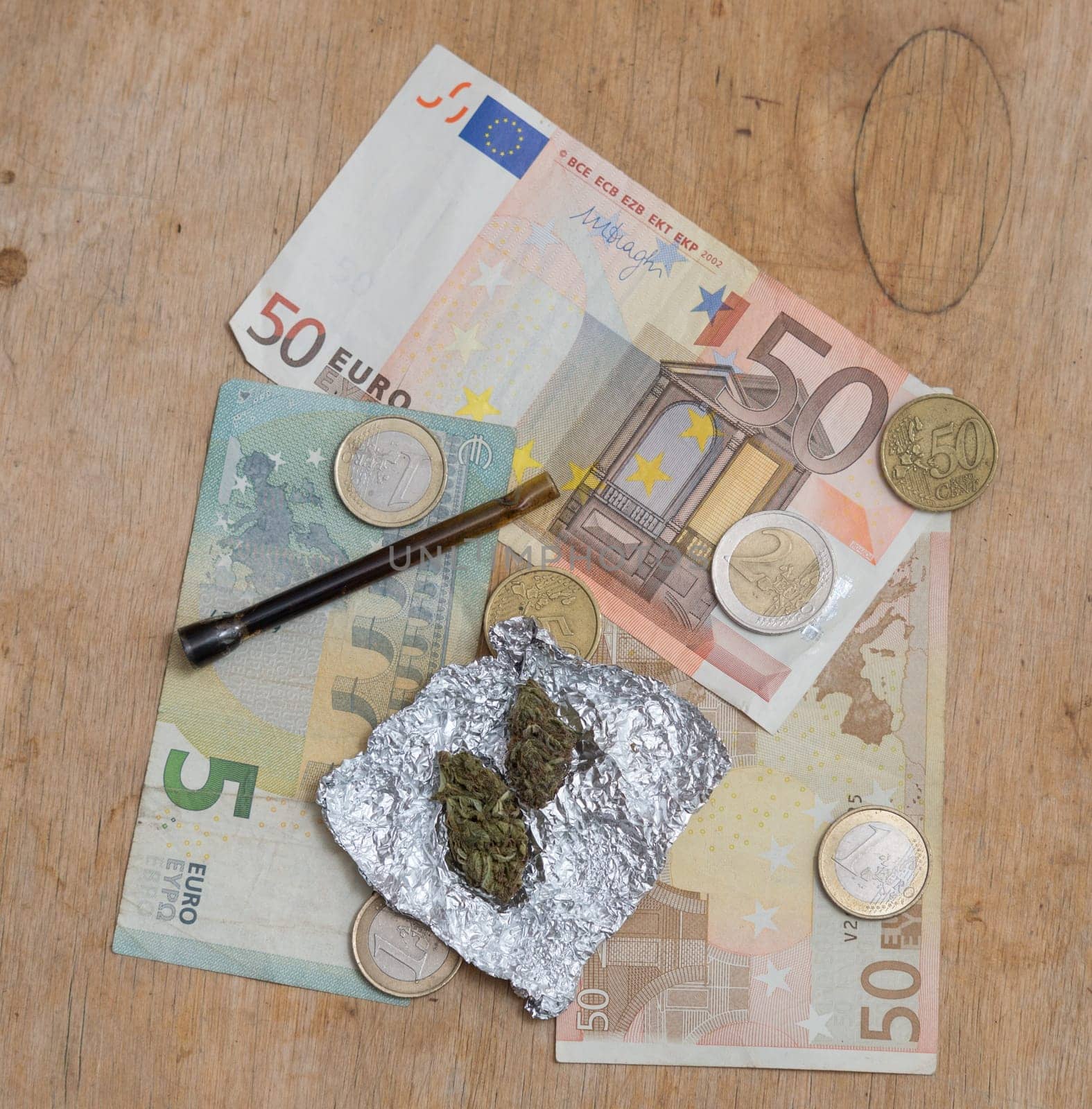 marijuana in tin foil with pipe and euro money background