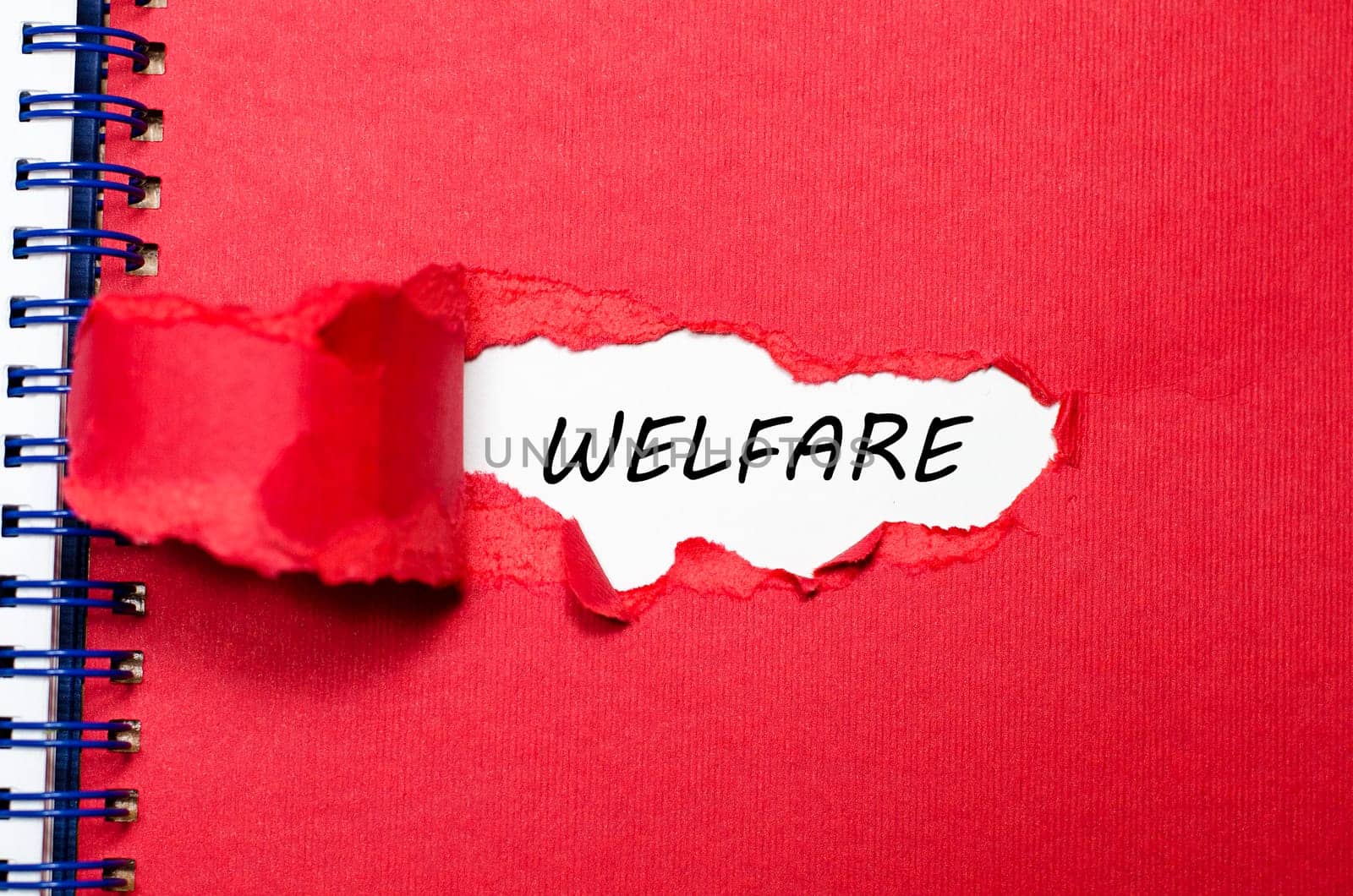 The word welfare appearing behind torn paper