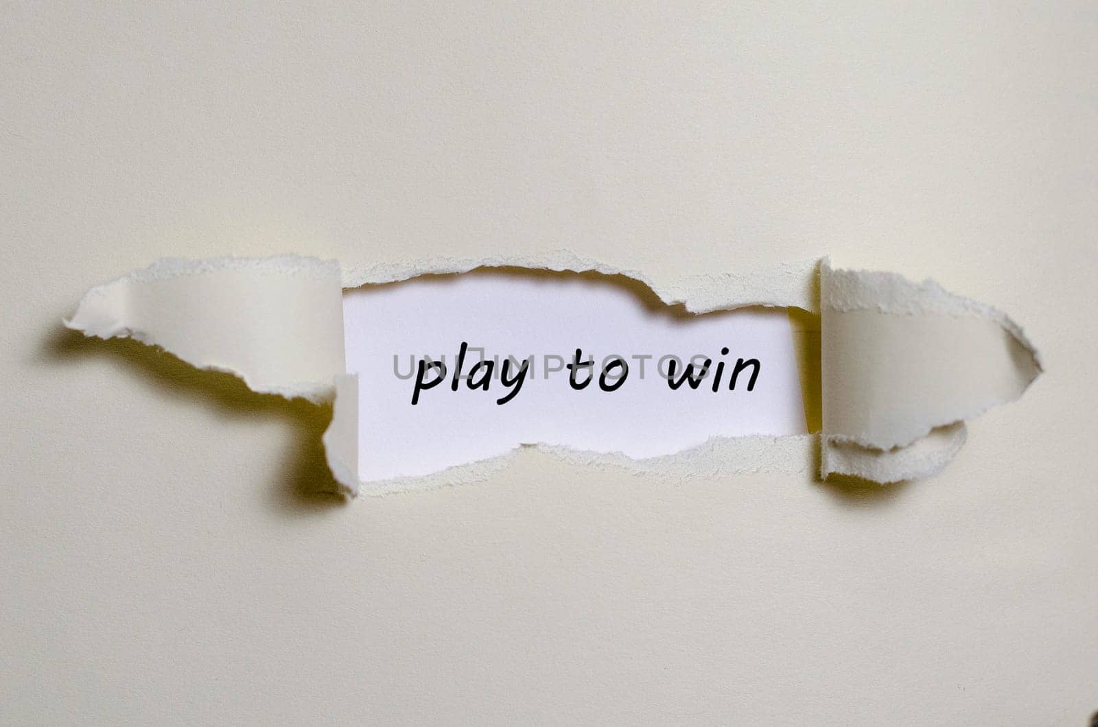 The word play to win appearing behind torn paper